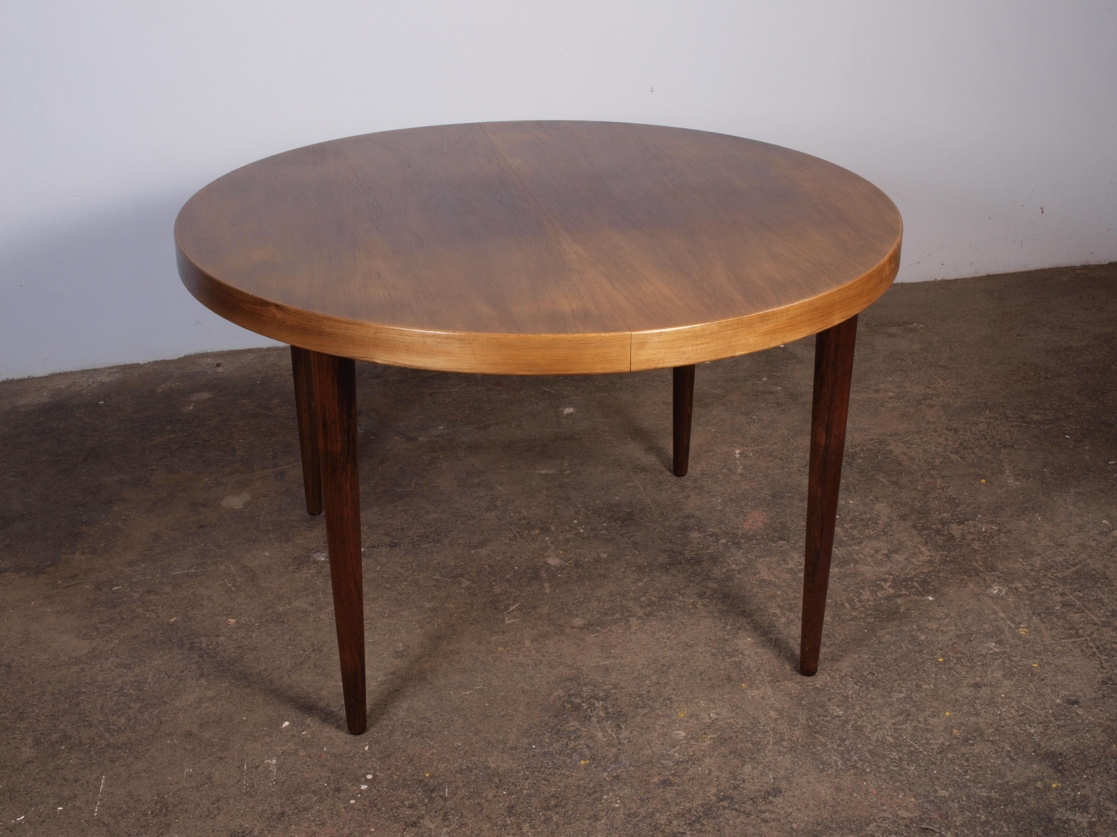 Well-maintained round rosewood dining table with extension leaves, attributed to architect Kai Kristiansen. Produced in the 1960s, this rare wood table is in excellent condition with no noticeable flaws. Cleaned and treated for preservation.