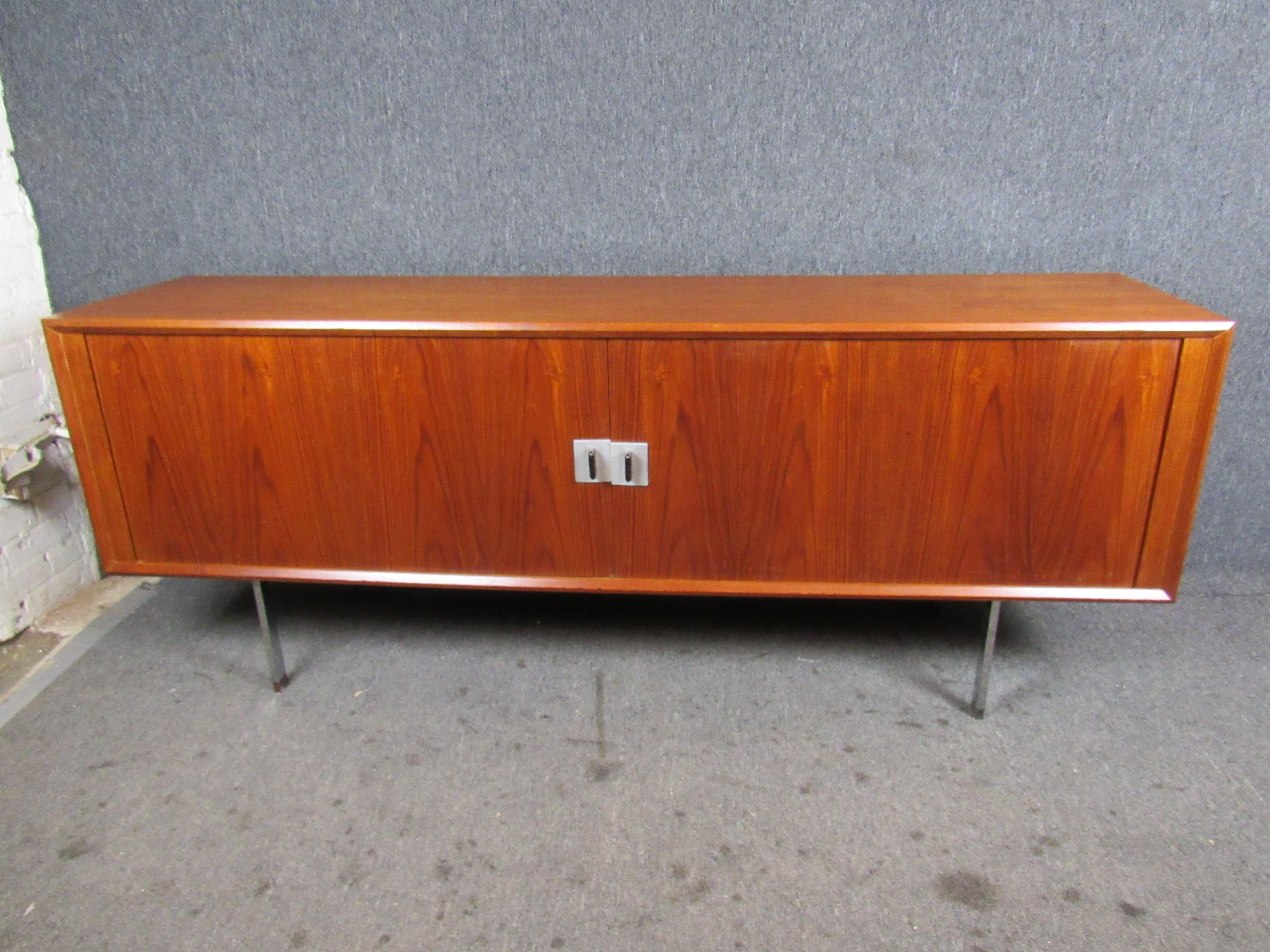 Mid-Century Modern Danish Credenza by Hans Wegner. Stunning credenza with tambour doors which reveal a spacious interior storage area. Inside includes modular shelving capabilities as well as three small drawers lined with soft wool material. The