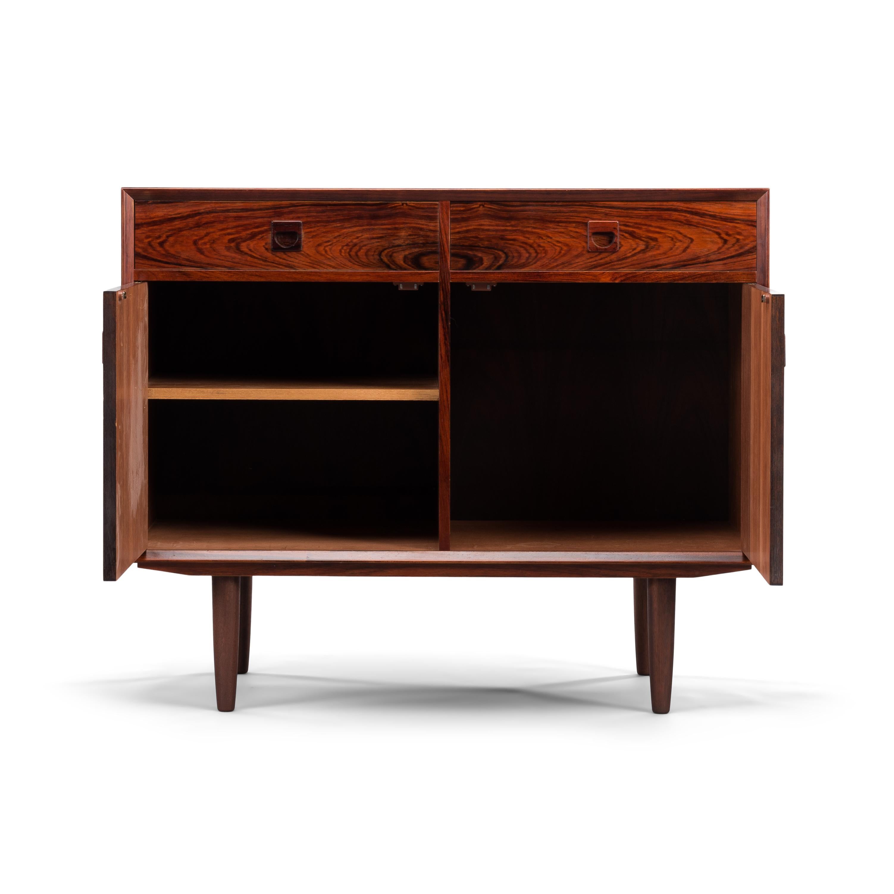 Small teak sideboard designed by E. Brouer and manufactured by Brouer Møbelfabrik. An eye-catcher in every hallway, study or living! This sideboard has a top layer of two drawers that fit like a glove. Underneath are two doors, behind one of the