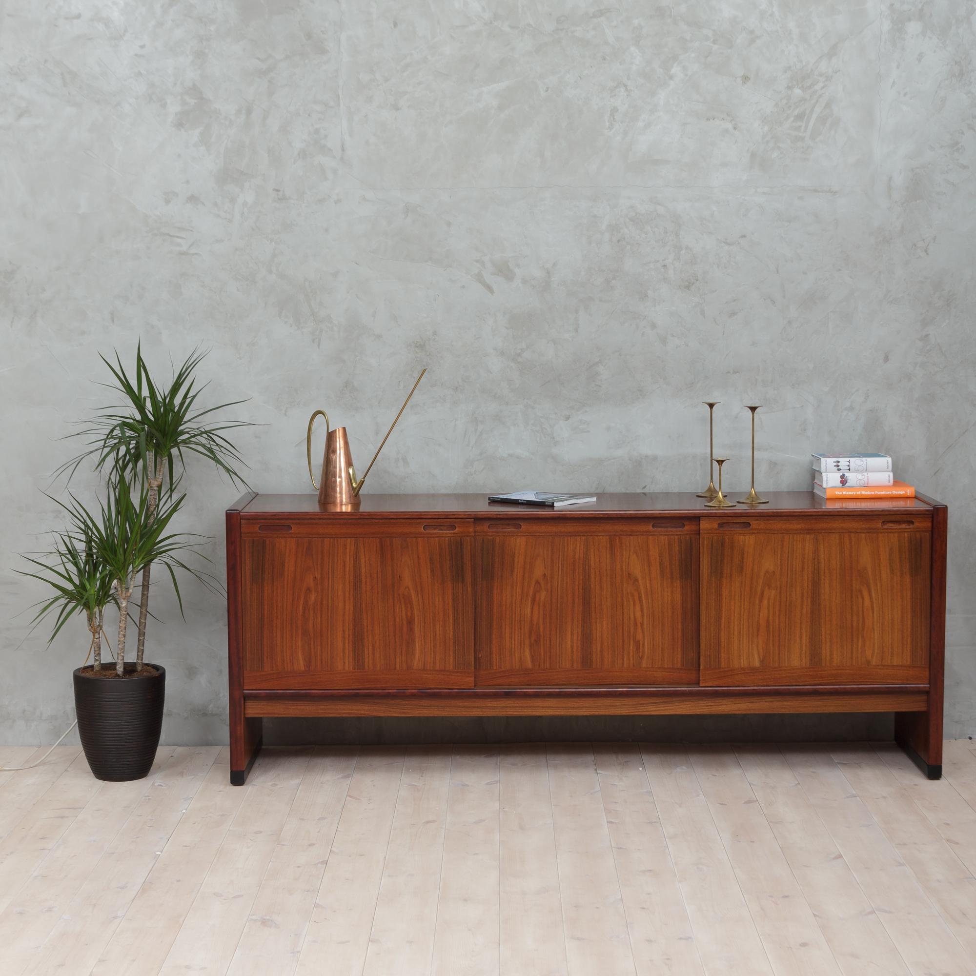 Rosewood sideboard manufactured by Skovby Møbelfabrik in Denmark in the 1960s. Minimalist form and a beautiful and rich drawing of wood. There are three sliding doors, behind which placed adjustable shelves and two small drawers. The piece is in