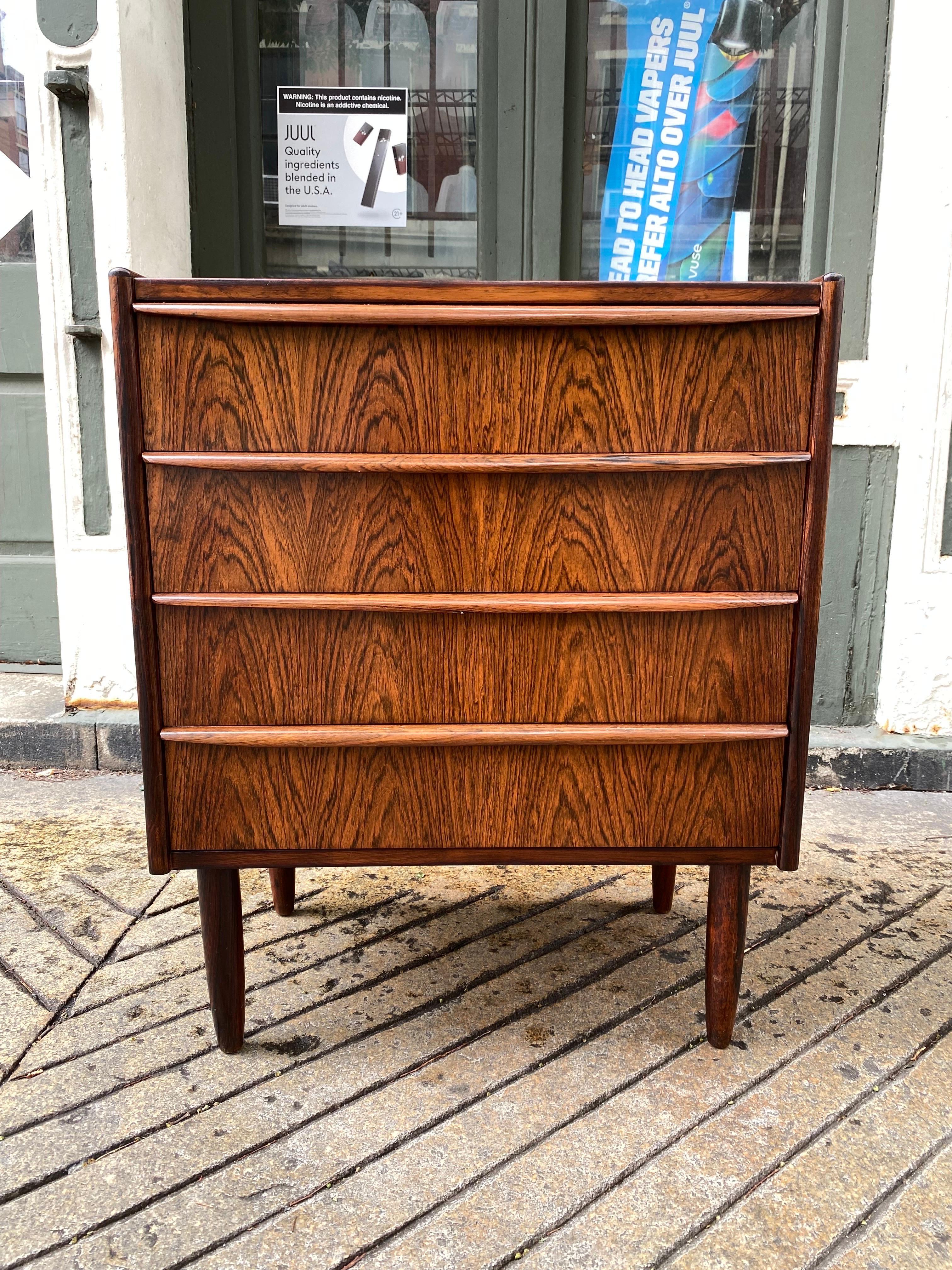 Small Rosewood 4 Drawer Dresser.  Beautiful veneer with curved wood handles.  Simple straight forward look!  Danish Made, legs unscrew for easy moving!  Looks like top was refinished within last 10 years.  Overall looks good!  One drawer handle has