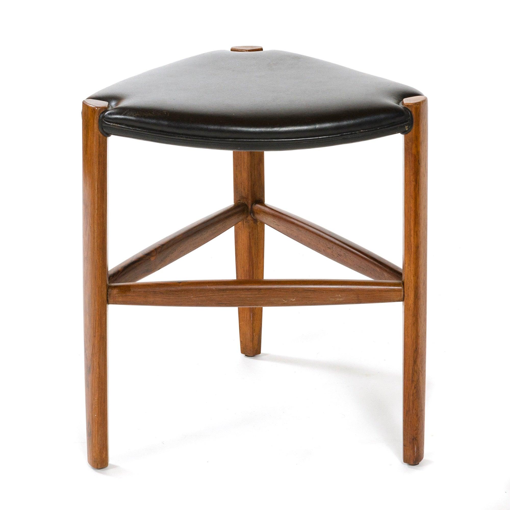 Tabouret danois en palissandre composé de trois pieds en palissandre massif de forme triangulaire aux angles adoucis, reliés par trois brancards tournés en palissandre massif. Le siège est composé d'un cuir de première qualité enveloppé sur trois