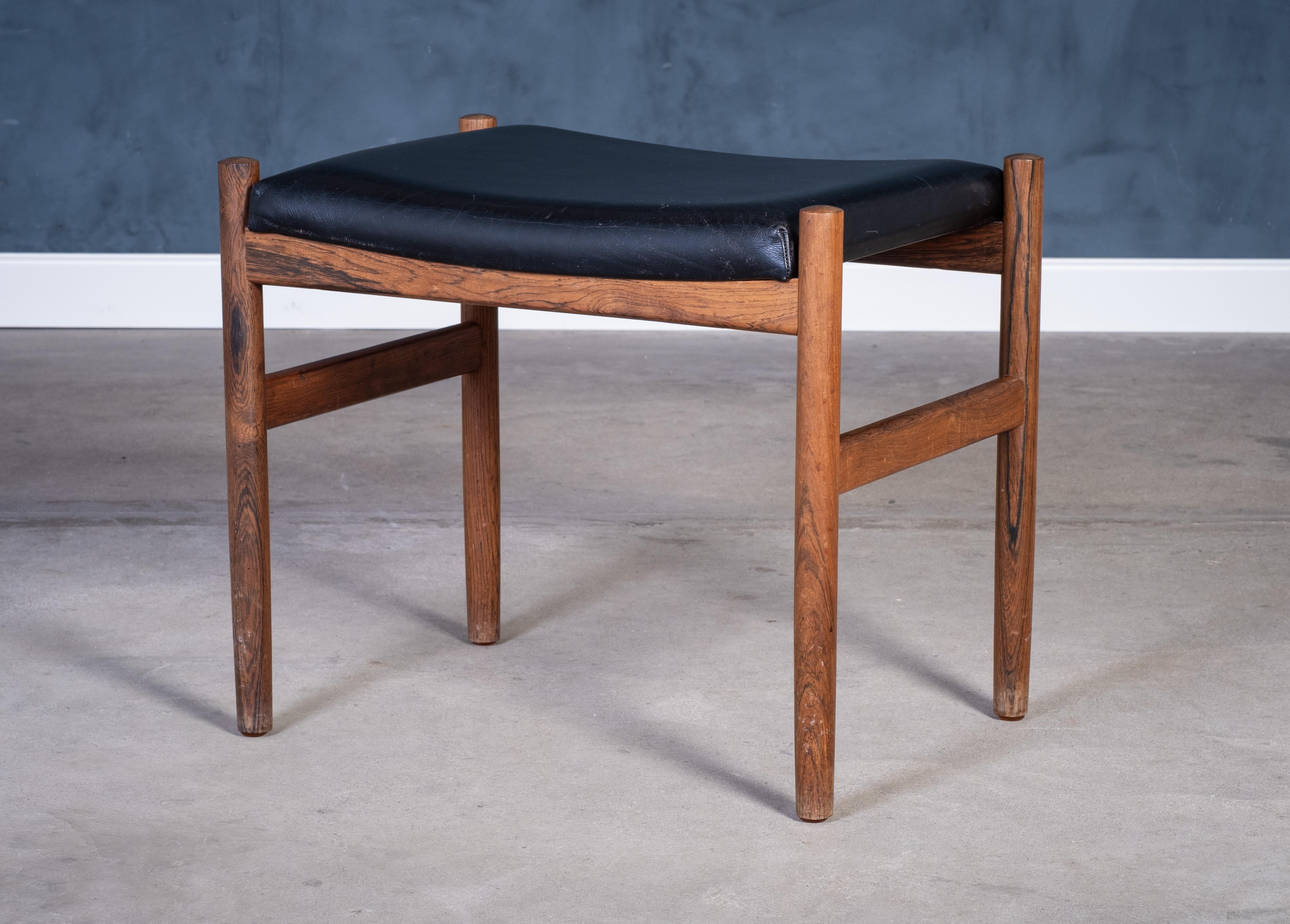 Beautiful rosewood stool from the 1960s, designer and maker unknown. The piece features a detailed and well-crafted frame paired with a black leather seat, combining mid-century elegance with practical function.

In very good vintage condition with