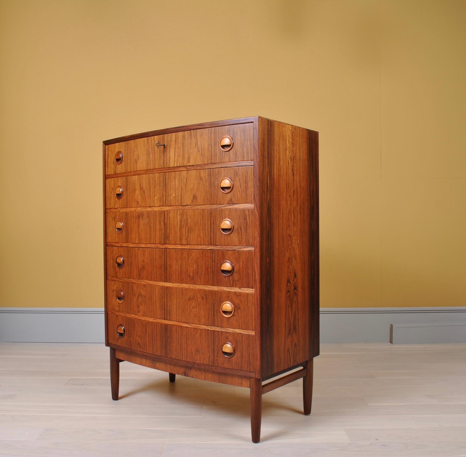 Substantial tallboy chest of drawers in rosewood. Designed by Kai Kristiansen and produced in Denmark in the late 1950s. Lockable top drawer. An elegant Midcentury piece and extremely practical.