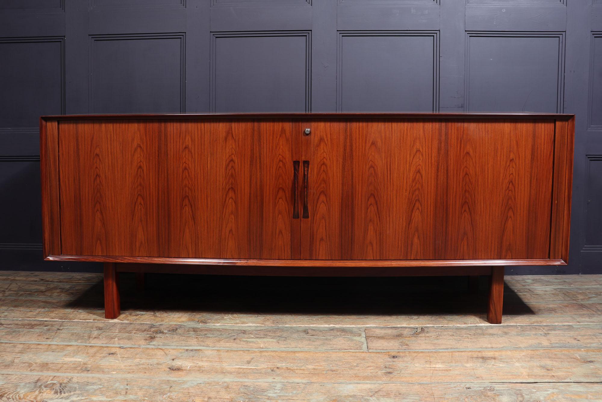 Tambour door sideboard by Arne Vodder.
A midcentury Danish sideboard designed by Arne Vodder and produced in Rosewood by Sibast in the 1970s. It has two tambour sliding doors that fully open to reveal four compartments of adjustable shelves sliding
