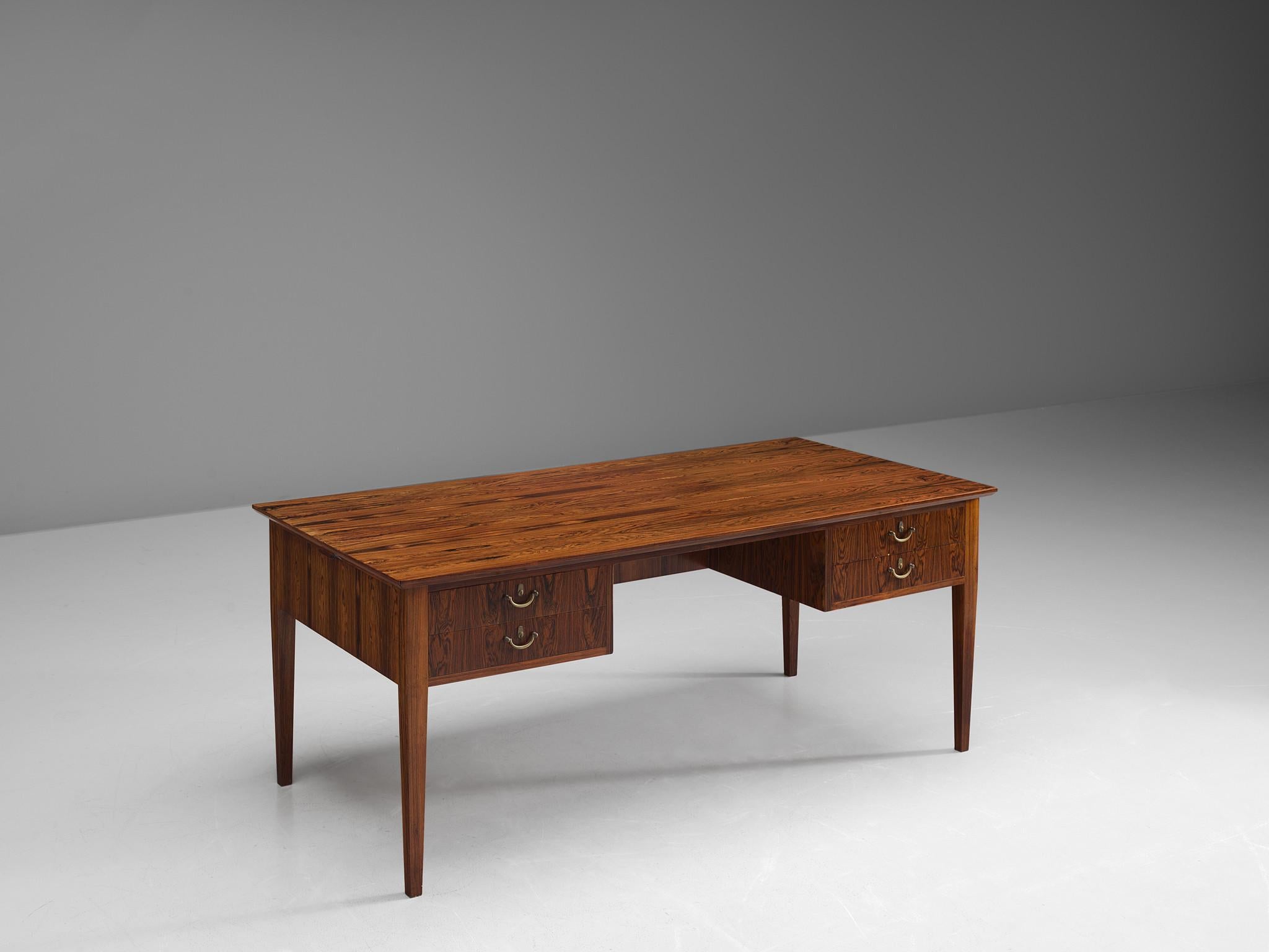 Desk, brass and rosewood, Denmark, 1950s.

This desk and writing table is executed in rosewood. It shows an extraordinary wood grain, which emphasizes the otherwise modest design of this piece. The design is sincere and class, and shows great eye