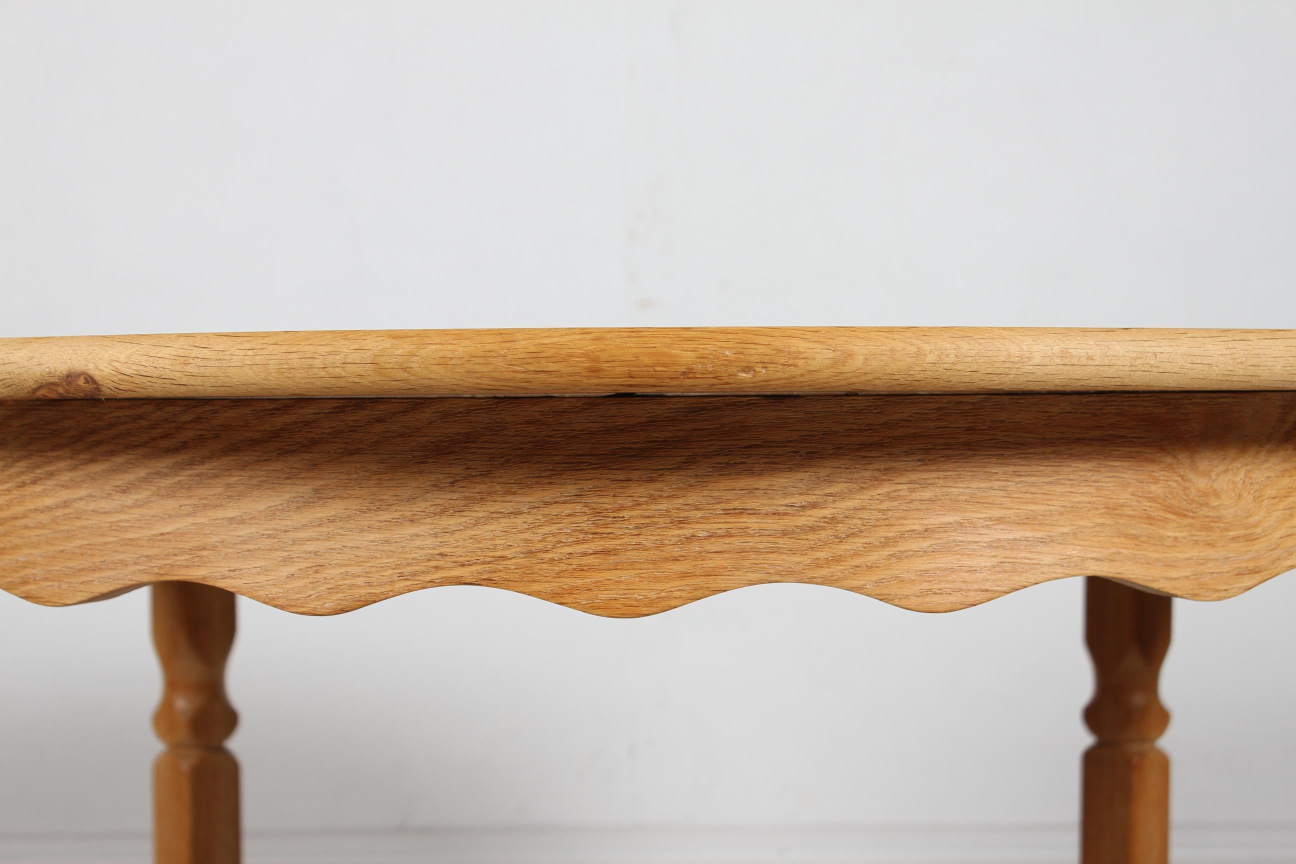 Danish vintage Henning Kjærnulf round extendable dining table with carved legs.
Manufactured in Denmark in the 1970s.

The table is made of solid oak (oak veneer on the leaves).
It can be extended with three extra leaves. 

Measures: Diameter 120