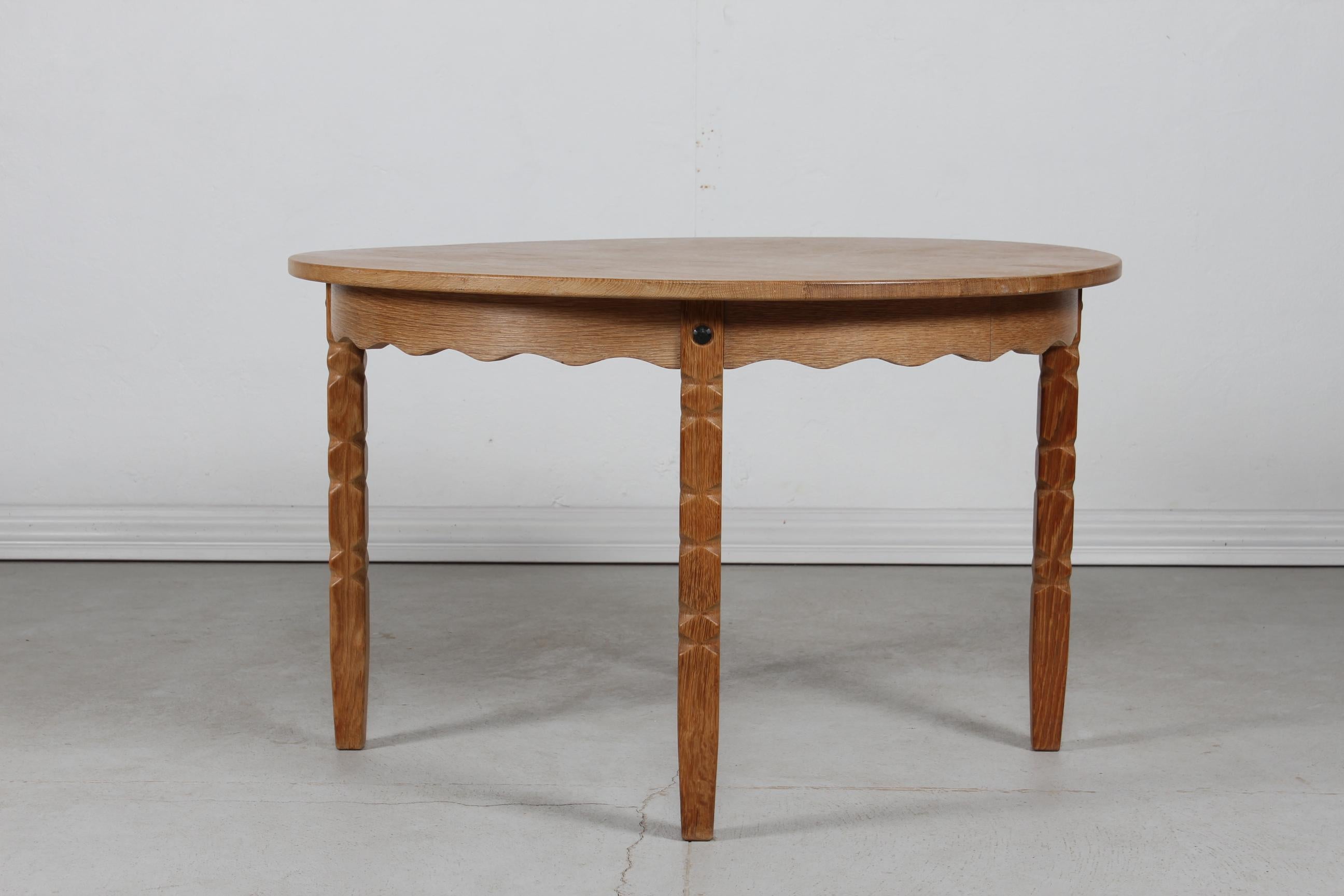 Danish vintage Henning Kjærnulf style round extendable dining table with curved legs.
Manufactured in Denmark in the 1970s.

The table is made of solid oak and oak veneer.
It can be extended with two pull-out-leaves. 

Measures: Diameter 120 cm
Max