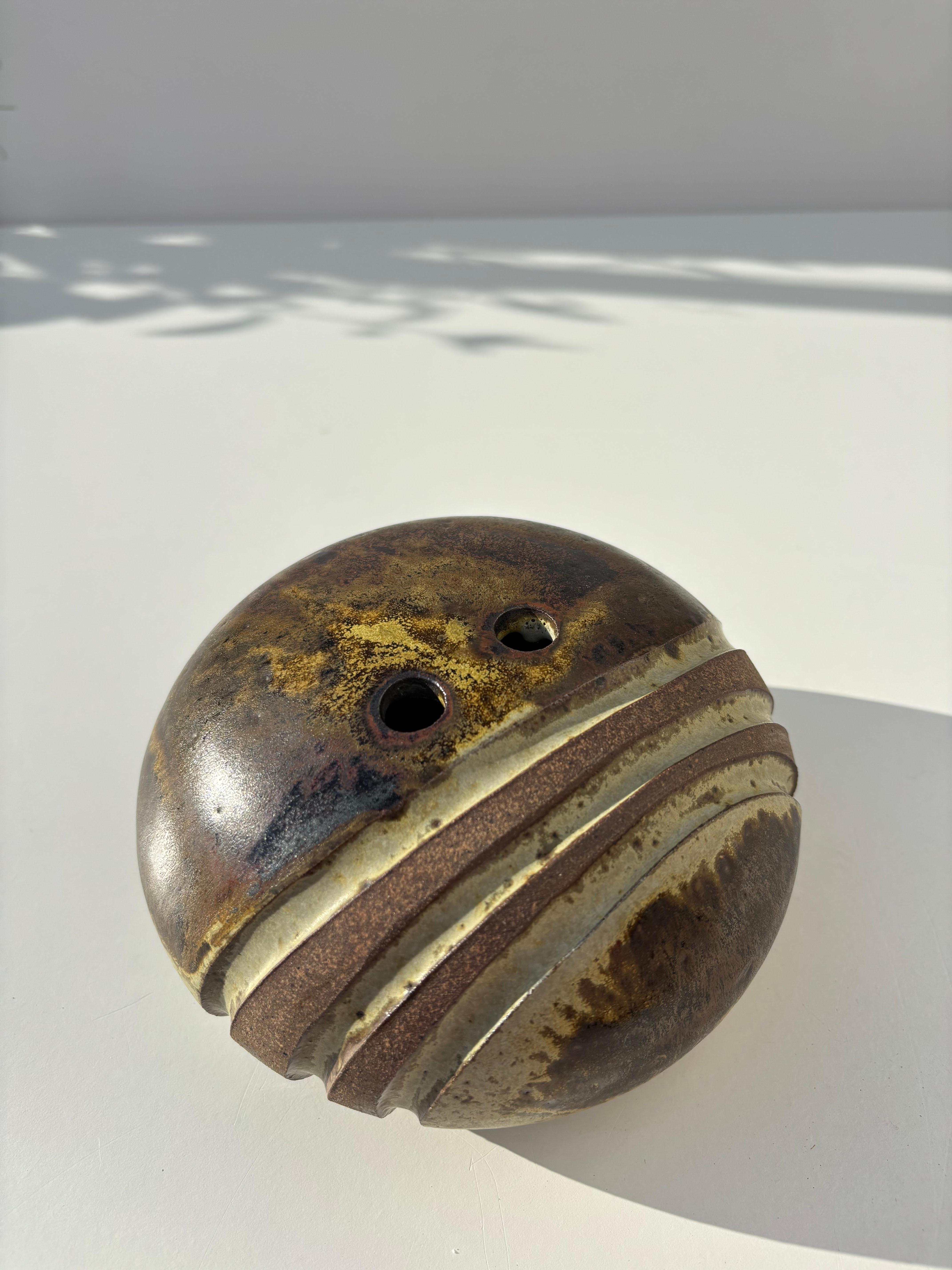Dänische Vase aus organischem, modernem Steingut mit schöner erdfarbener brauner und hellgrüner Glasur. Zwei Löcher für Kerzen oder Blumen am Hals der Vase. Drei dekorative Relieflinien auf einer Seite.
Hergestellt von dem Keramikkünstler Aage Würtz