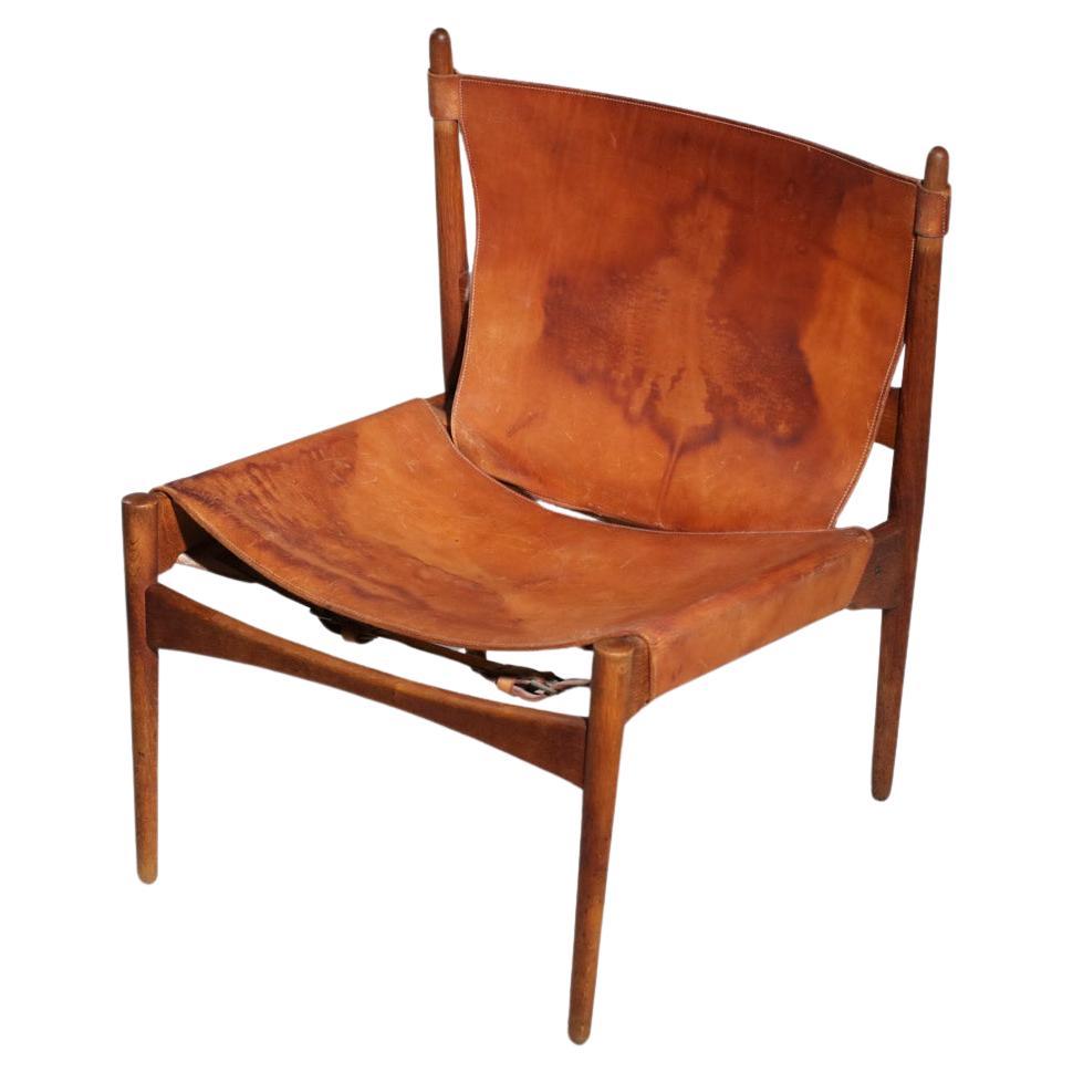 Danish safari armchair in patinated leather and teak from the 60's For Sale