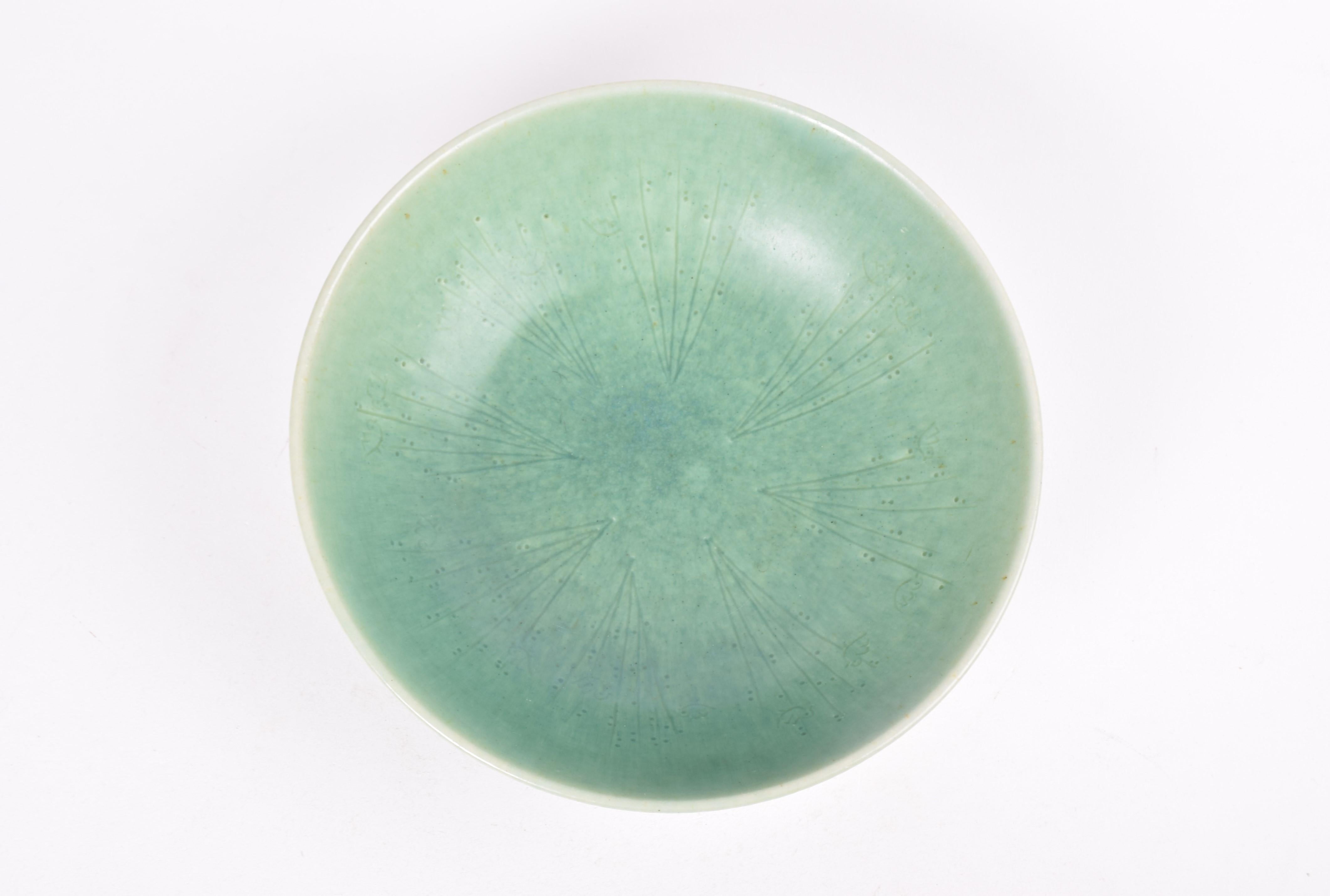 Danish mid-century ceramic bowl from the legendary workshop Saxbo, made ca. 1950s. The bowl has a repeated stylised decor of long grass straws or weeds surrounded by small birds. The bowl doesn´t have the signature of the designer which is often