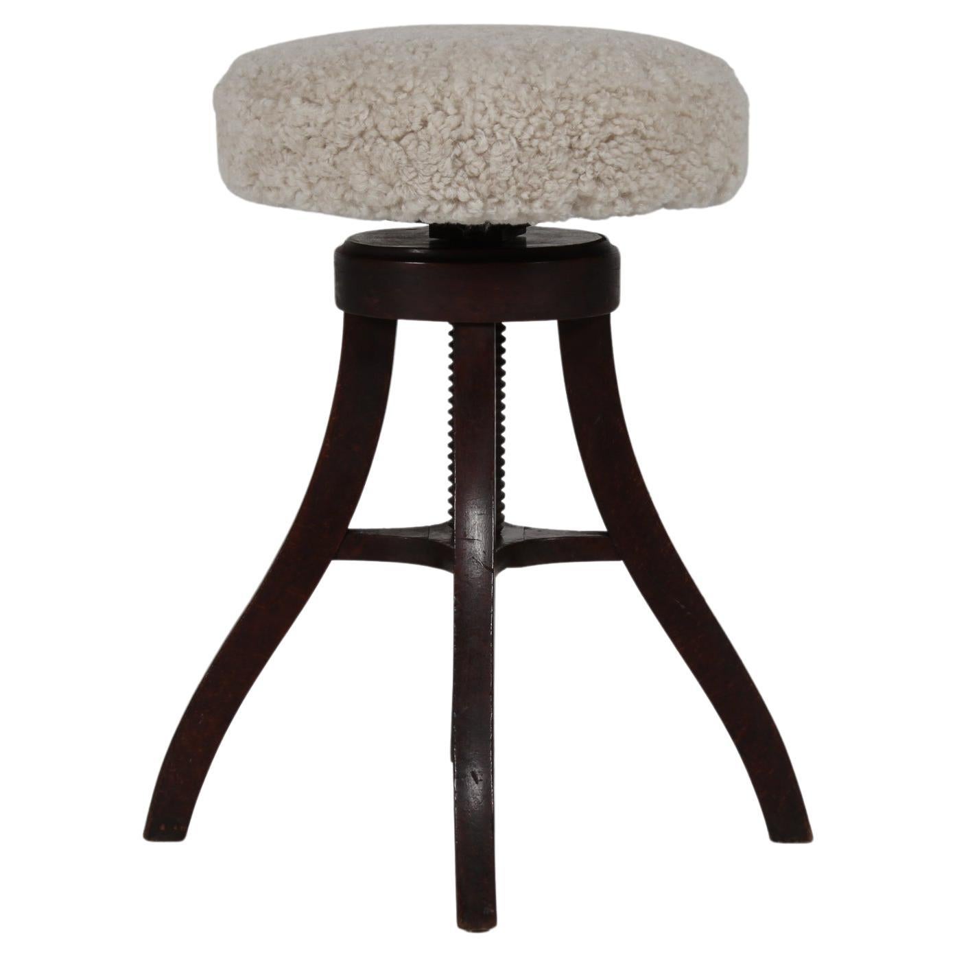 Tabouret de bar/tabouret de bureau/tabouret de bar danois tripode réglable en hauteur en bois massif teinté foncé avec assise ronde recouverte de peau de mouton neuve.
Fabriqué vers les années 1920 par un ébéniste danois (Fritz Hansen).
Il est