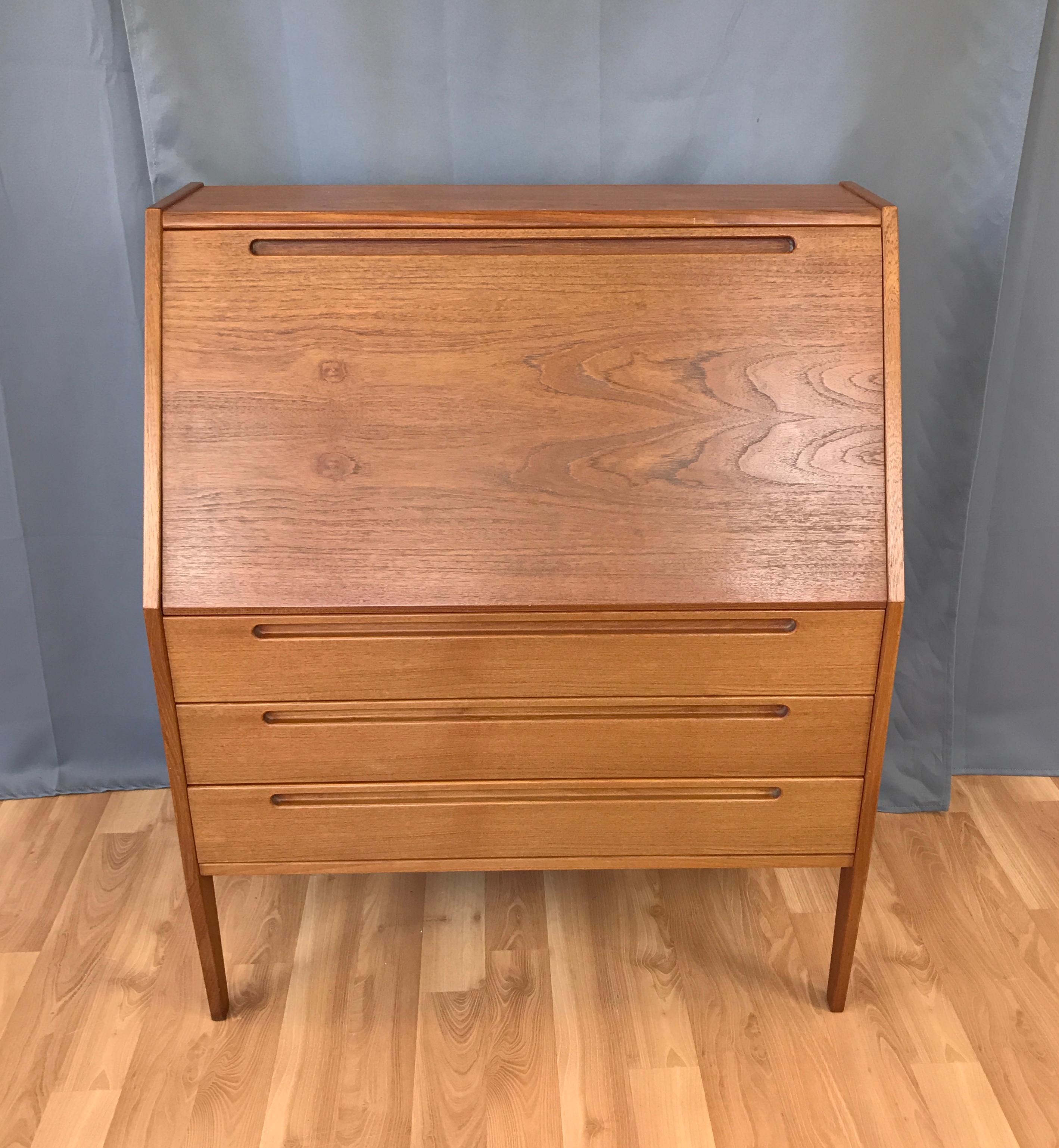 A Danish modern teak secretary by Nils Jonsson for HJN Møbler, circa 1960s

It's practical yet elegant. Simple tapered legs support a 3 drawer base for storage. The desk surface folds closed to hide all the paper while the flat top is the perfect