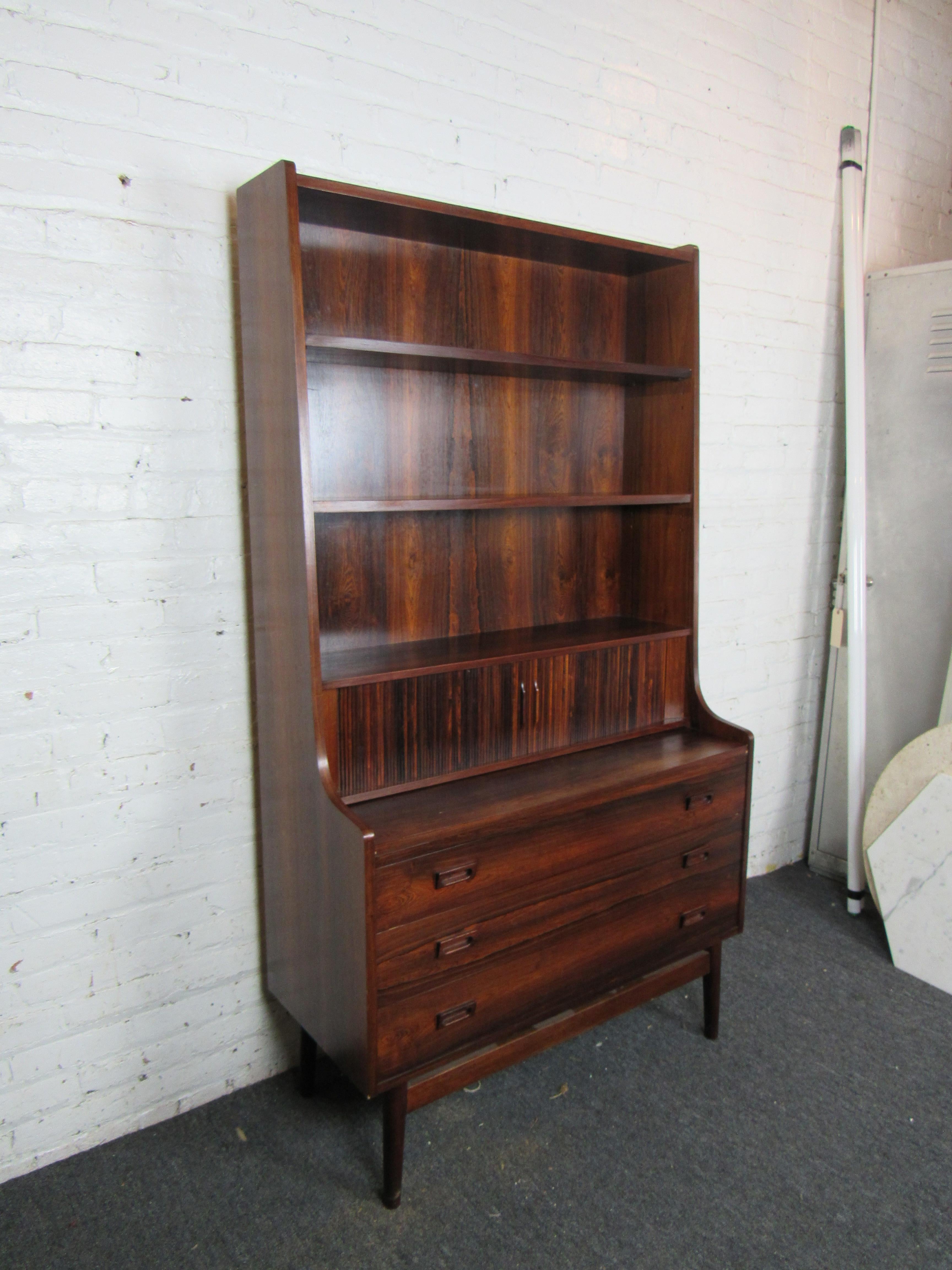 An incredible vintage secretary dresser in rich rosewood, this Mid-Century Modern piece offers generous storage through three drawers as well as shelves for displaying items. Please confirm item location with seller (NY/NJ).