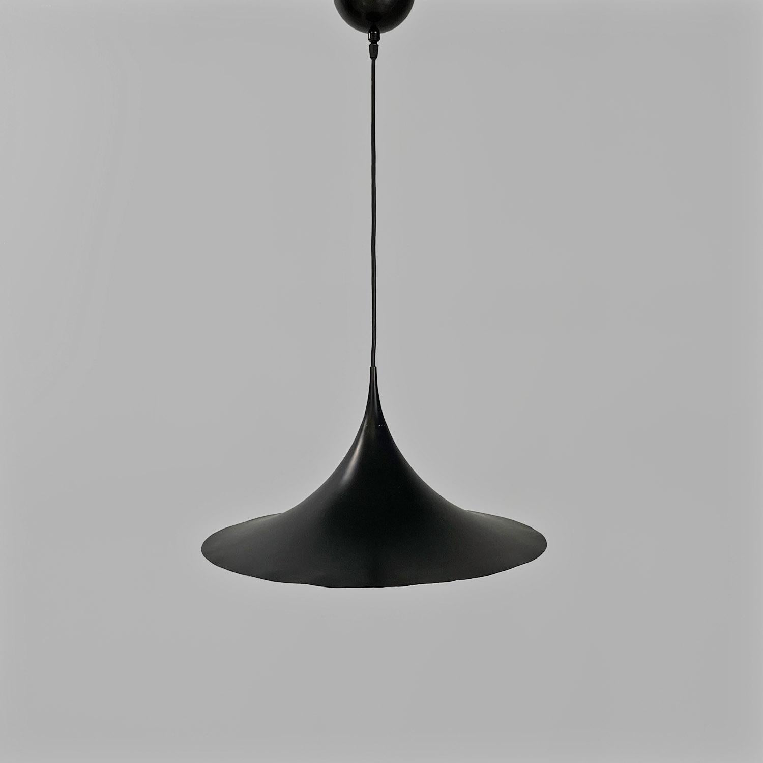 Lampadario semi-modello, di grandi dimensioni, con paralume a base rotonda in alluminio smaltato bianco all'interno e nero opaco all'esterno. The cable and the ceiling connection are also in black.
Prodotto da Fog & Mørup nel 1955 e disegnato da