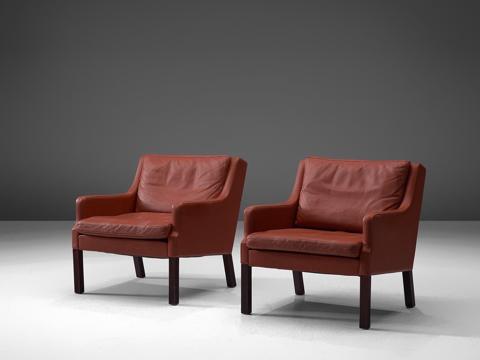 Lounge chairs, leather, mahogany, Denmark, circa 1960s–1970s.

This set is quintessentially Danish. Comfortable, well made and simplistic in design yet rich in use of material and finished. The set features patinated red to brown leather and