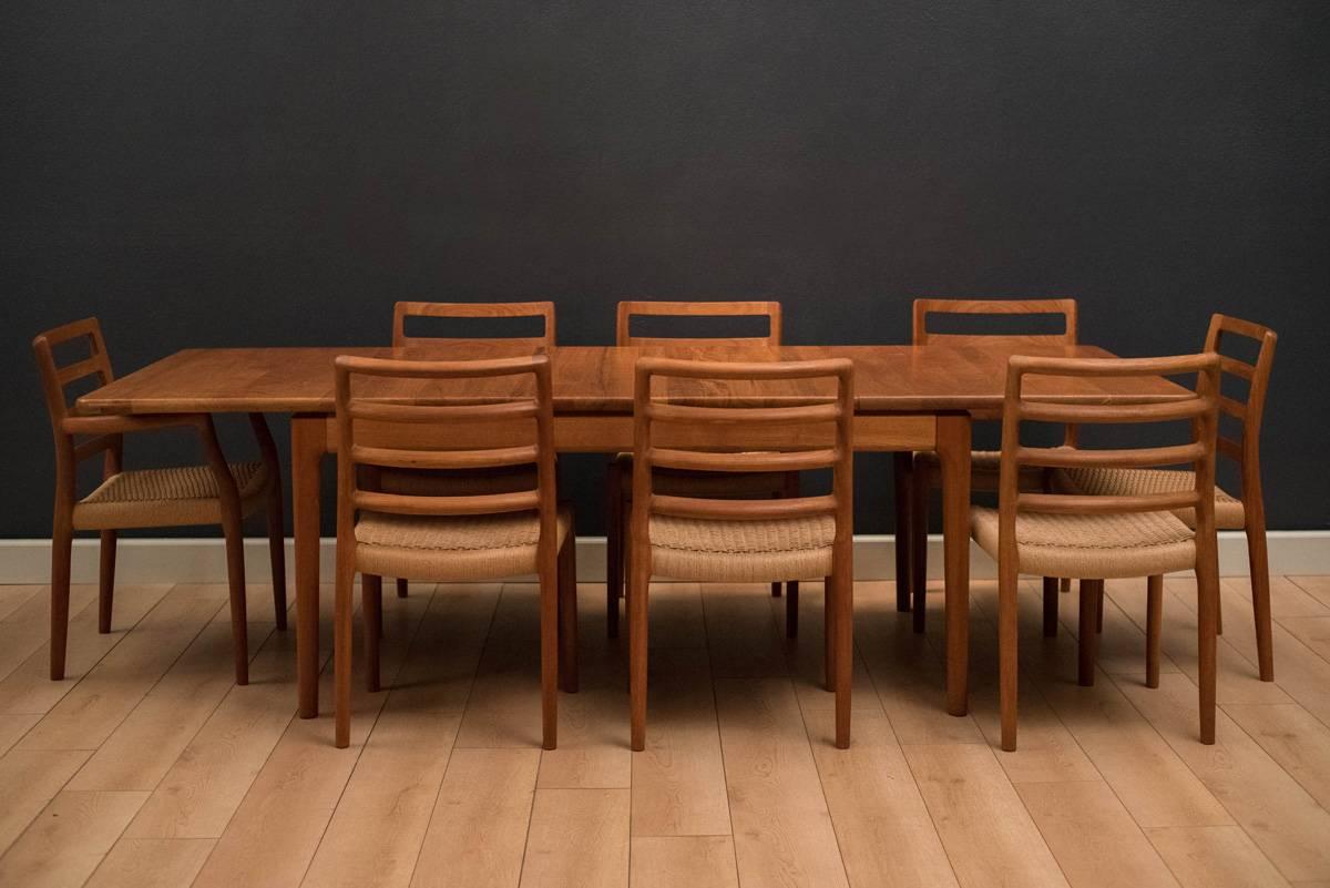 Vintage set of eight dining chairs in teak by Niels O. Møller for J.L. Moller. This set includes one captain armchair and seven side chairs. Natural woven papercord seats are original and intact.

Captain chair: 23