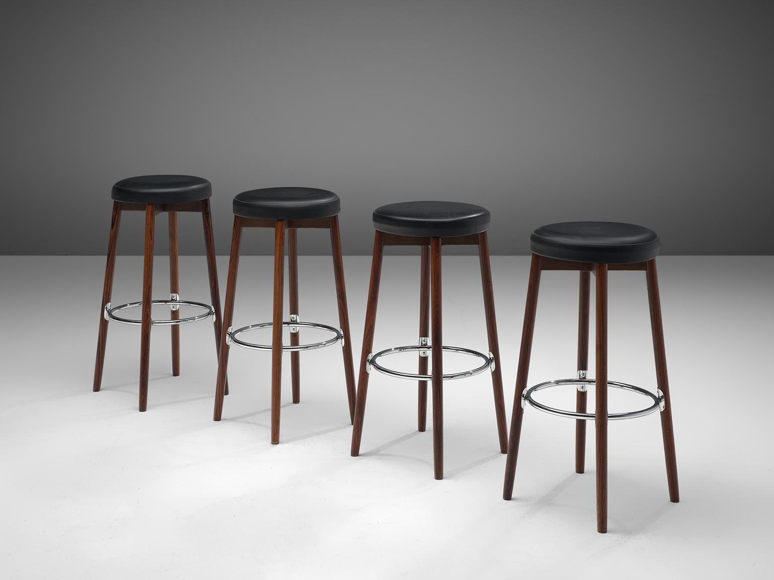Hugo Frandsen for Spøttrup Mobler, set of 4 barstools, leatherette, metal and rosewood, Denmark, 1960s.

This set of 4 bar stools, designed by Hugo Frandsen, is very solid and modest in its appearance. The metal ring that connects the four