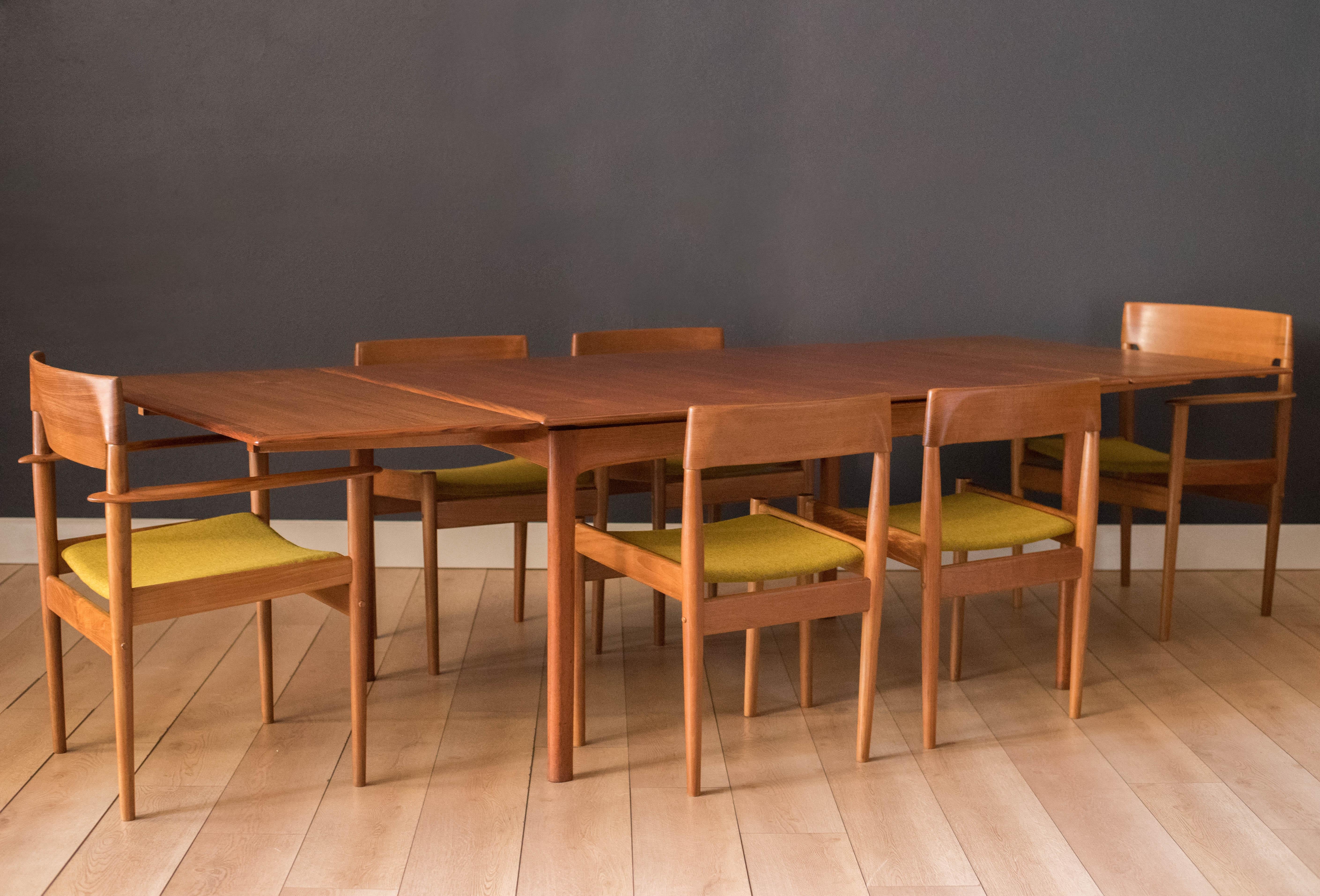 Mid-Century Modern dining chairs designed by Grete Jalk for P. Jeppesen, Denmark. This set of six features sculpted teak frames and has been newly reupholstered in a chartreuse yellow textile by Maharam. Includes four side chairs and two captain