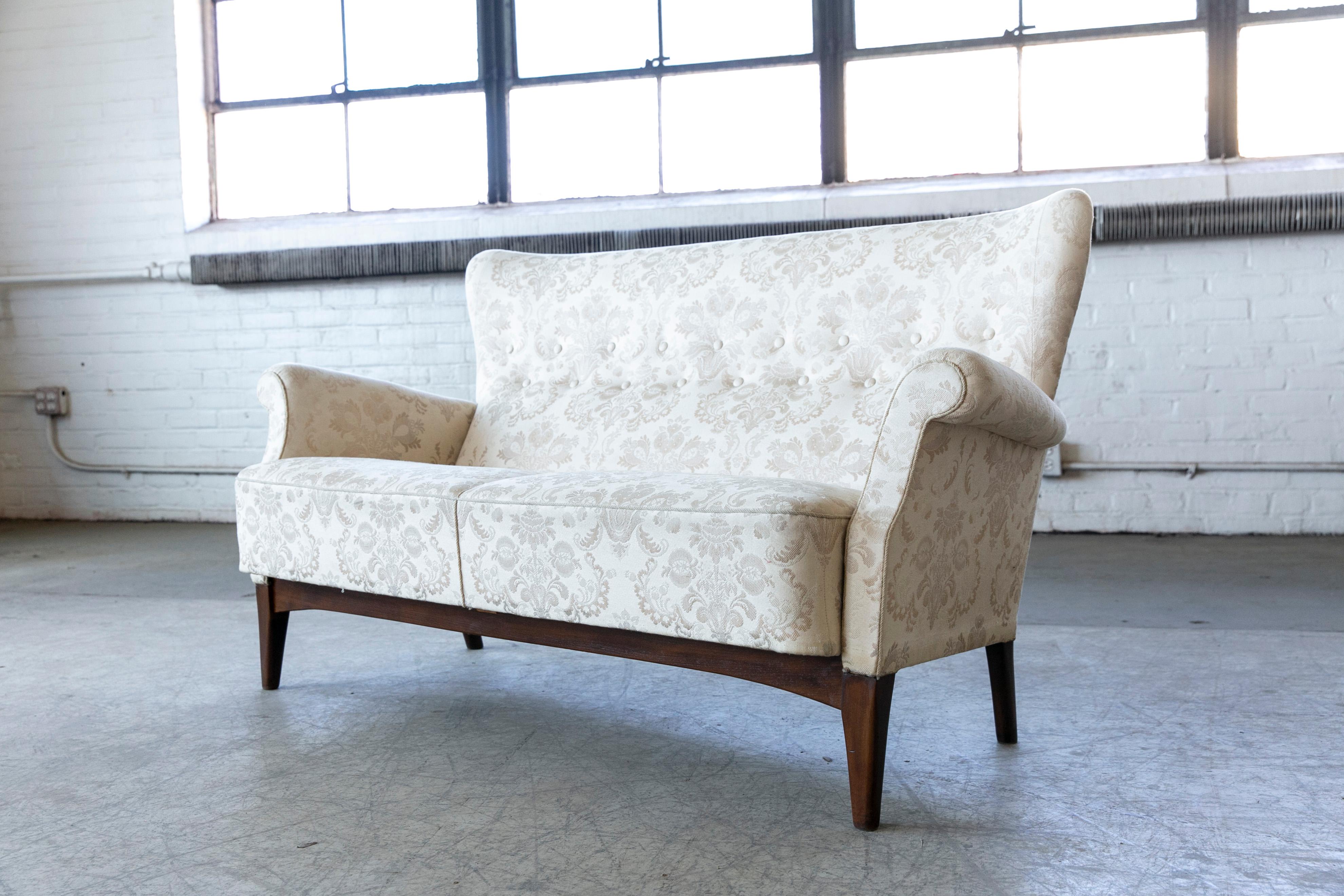 Very elegant settee or two-seat sofa model 8112 made by Fritz Hansen sometime in the early to mid-1950s in Copenhagen, Denmark. The frame is construed similar to Fritz Hansen's armchairs of the 1940s allowing it to be disassembled without use of