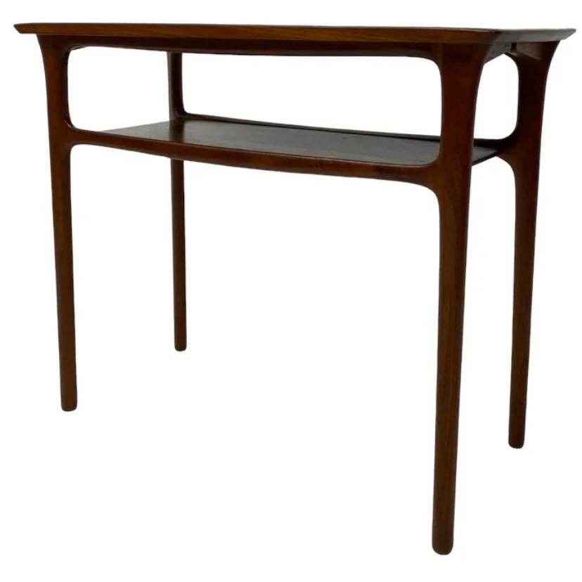 A stunning piece of midcentury Danish furniture by Paul Severin. This beautiful console table in the rich tone & grain of teak is a very elegant piece. The console table has slender legs, attractive rounded corners & a shelf. The console is in very