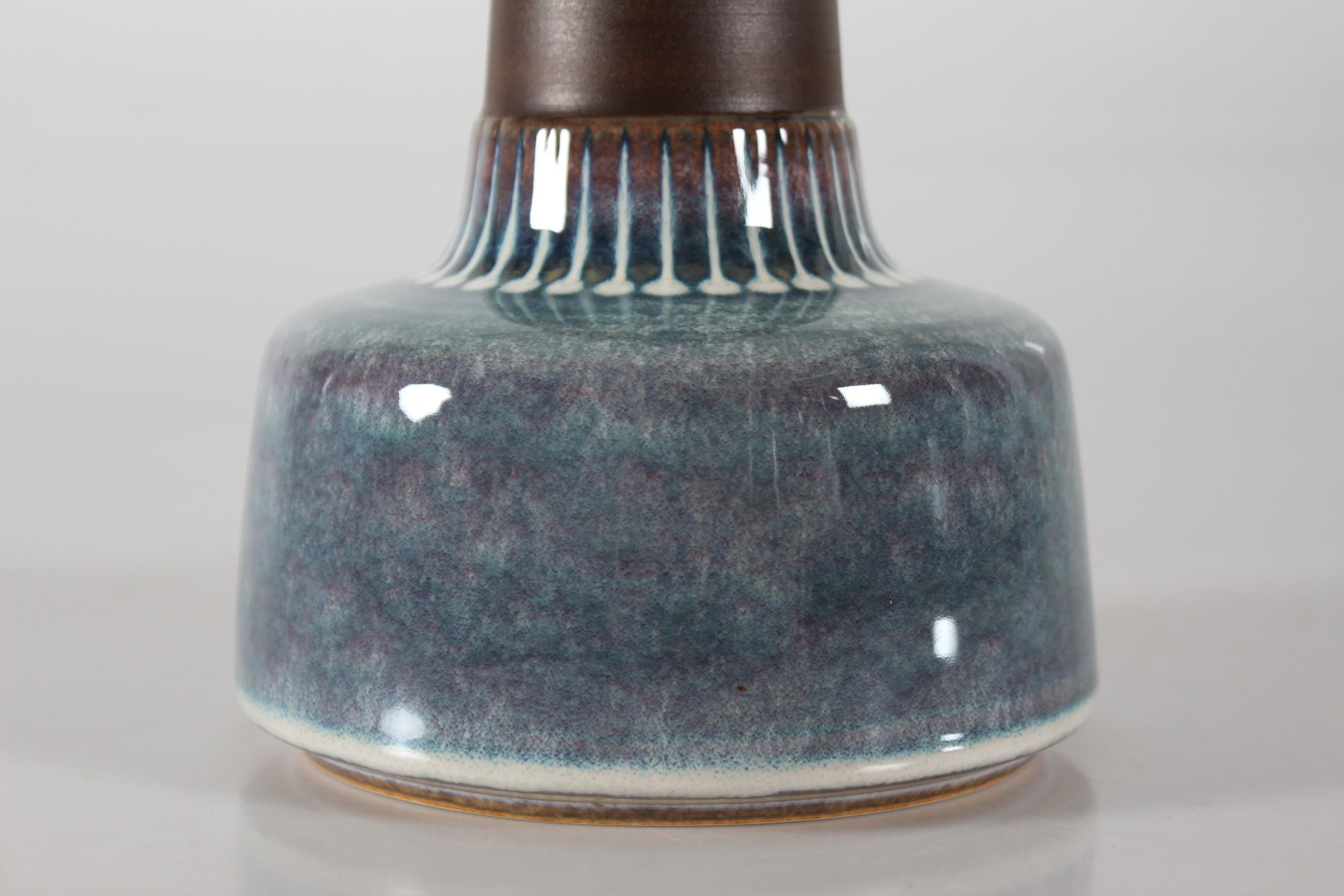 Dänische Tischlampe aus der Mitte des Jahrhunderts vom dänischen Keramiker Einar Johansen für Søholm. Hergestellt in den 1960er Jahren.

Der Lampenfuß hat einen matten braunen Hals, der durch eine glänzende Glasur in Perlmuttfarben und kreisförmige