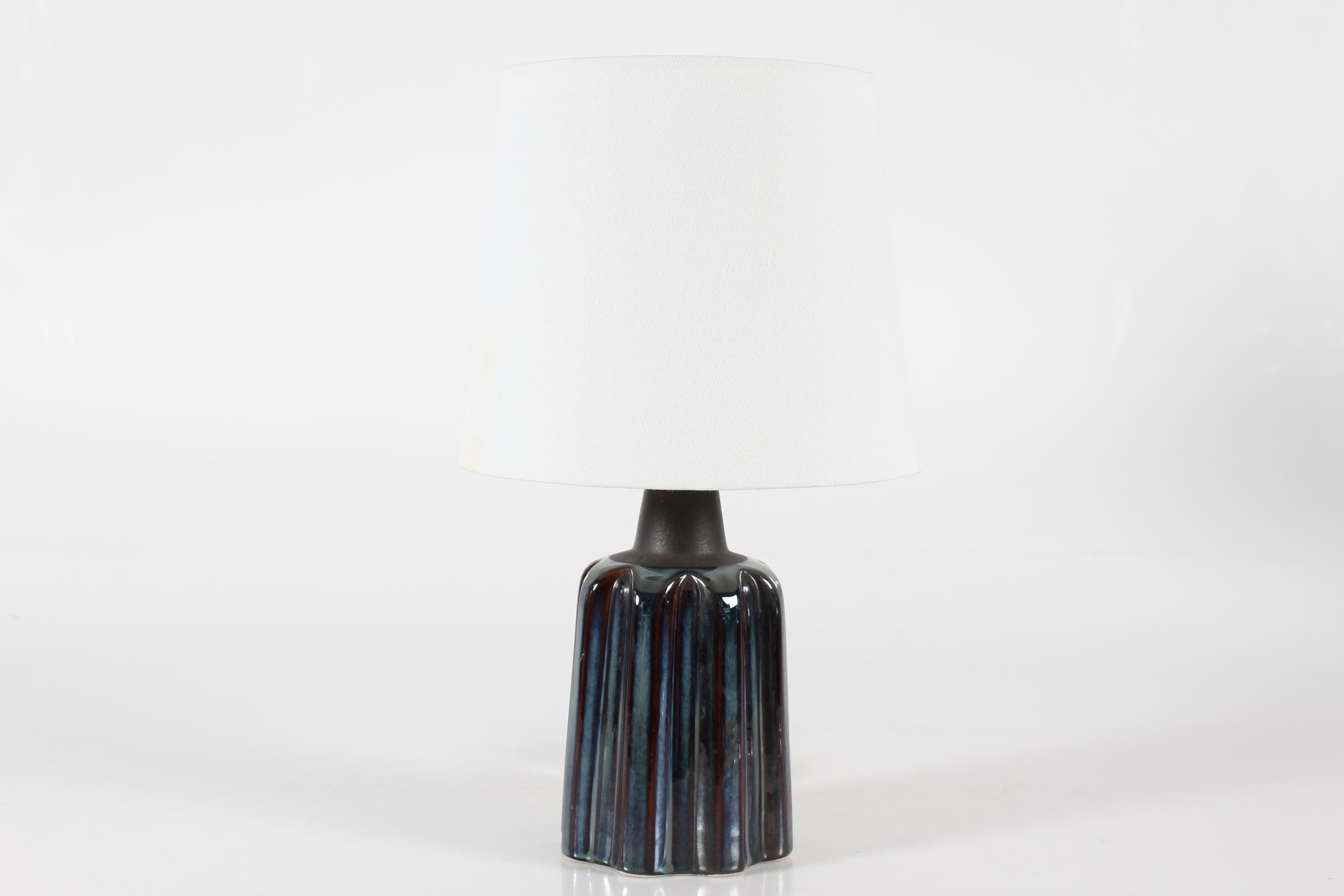 Lampe de table sculpturale en grès d'Einar Johansen pour Søholm Stentøj, Danemark, vers les années 1960.
La forme sculpturale et la glaçure bleue brillante avec des éléments bruns donnent à la lampe une expression très vivante. Le col de la base est