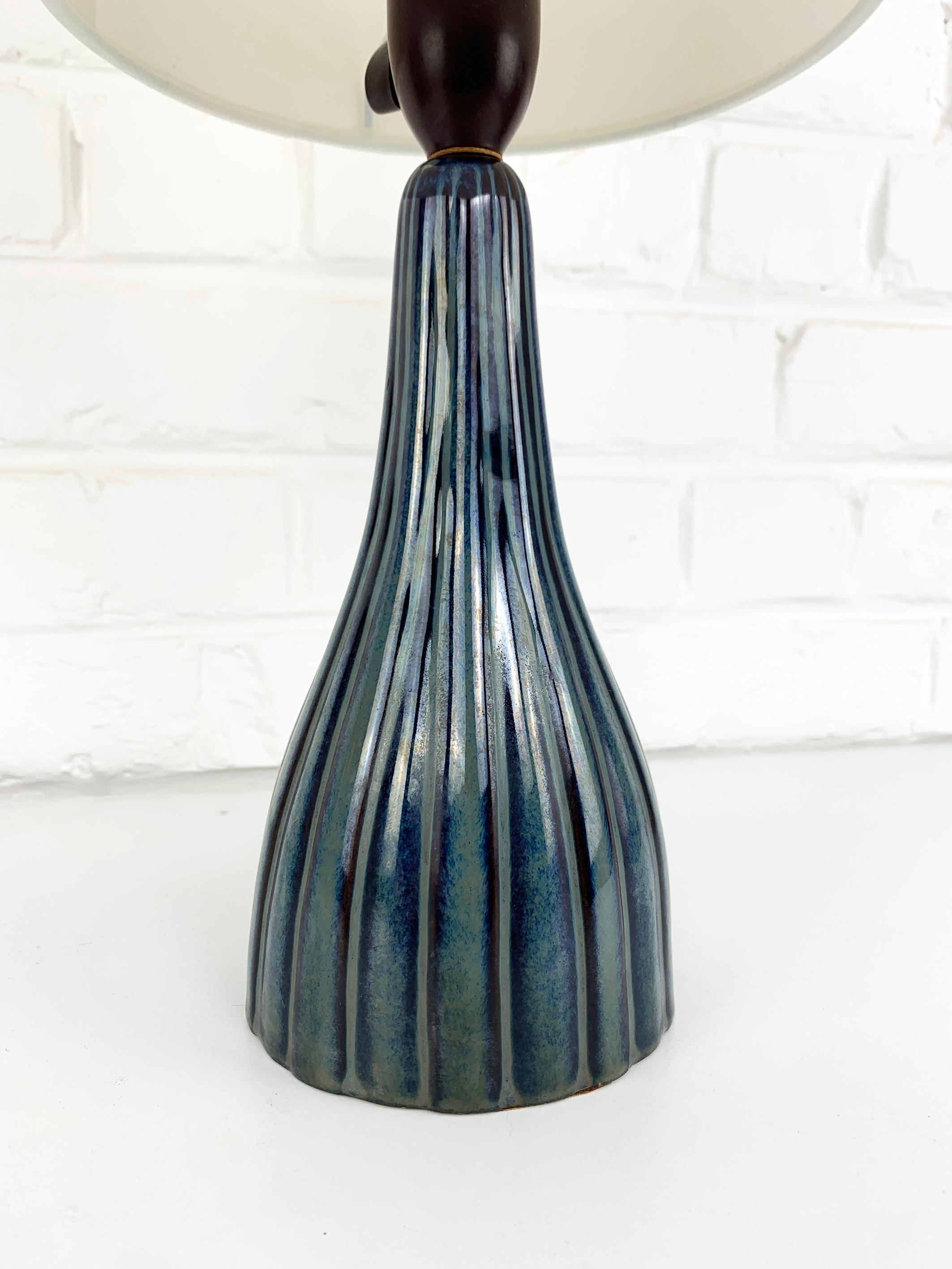 Dänische Keramik-Tischlampe aus der Jahrhundertmitte der 1950-60er Jahre. Sehr elegantes Design, verziert mit einem Streifenmuster in blau-grauen Farben.

Unbekannter Designer, aber der Stil der Kreationen von Svend Aage Jensen und Svend Aage