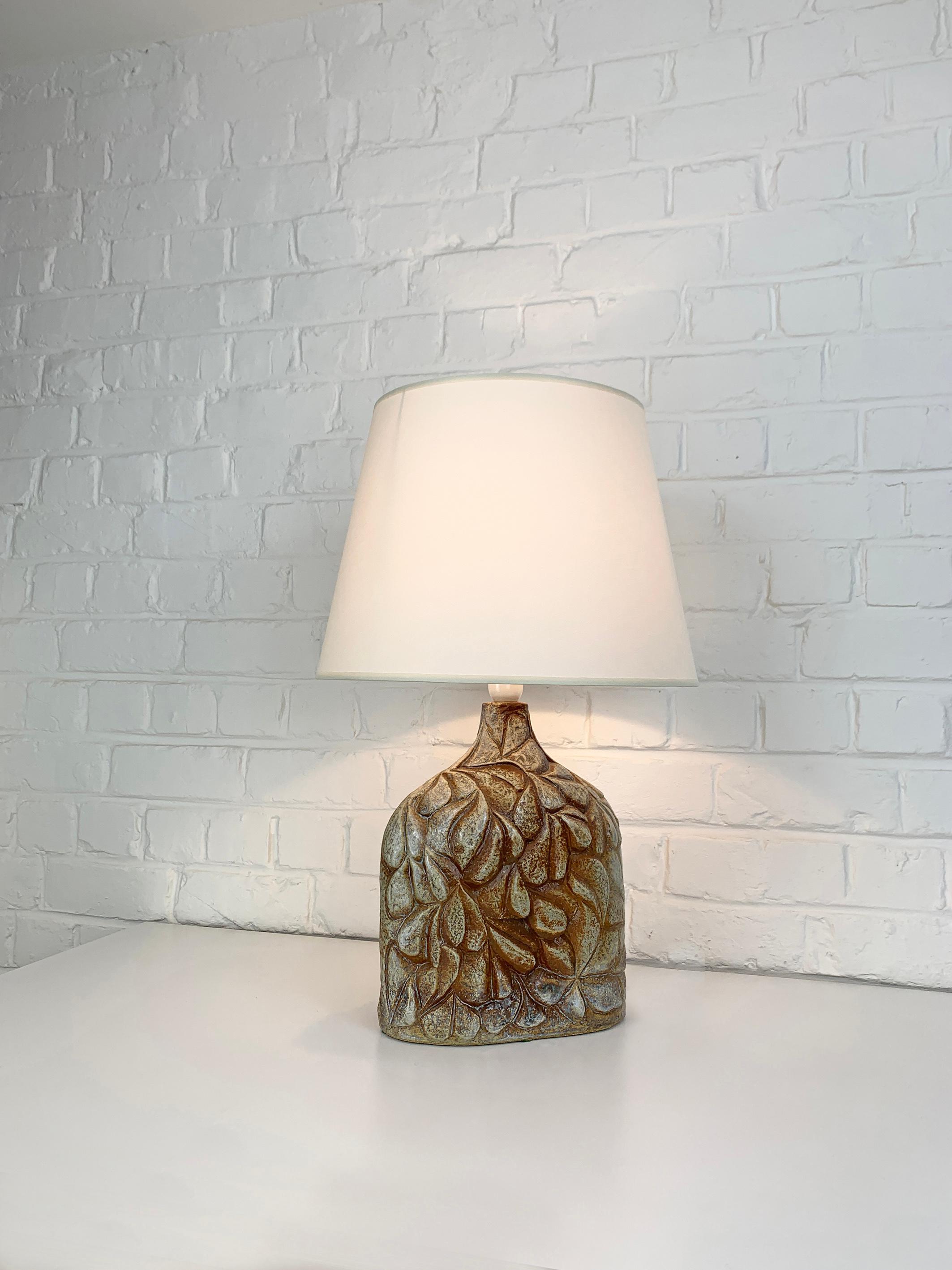 Danish Mid-Century stoneware table lamp of the 1970s, attributed to Haico Nitzsche. Sculptural lamp in earthy colored glazed stoneware. 

Haico Nitzsche trained in ceramics in Germany before teaching at the National Institute of Design in Ahmedabad,