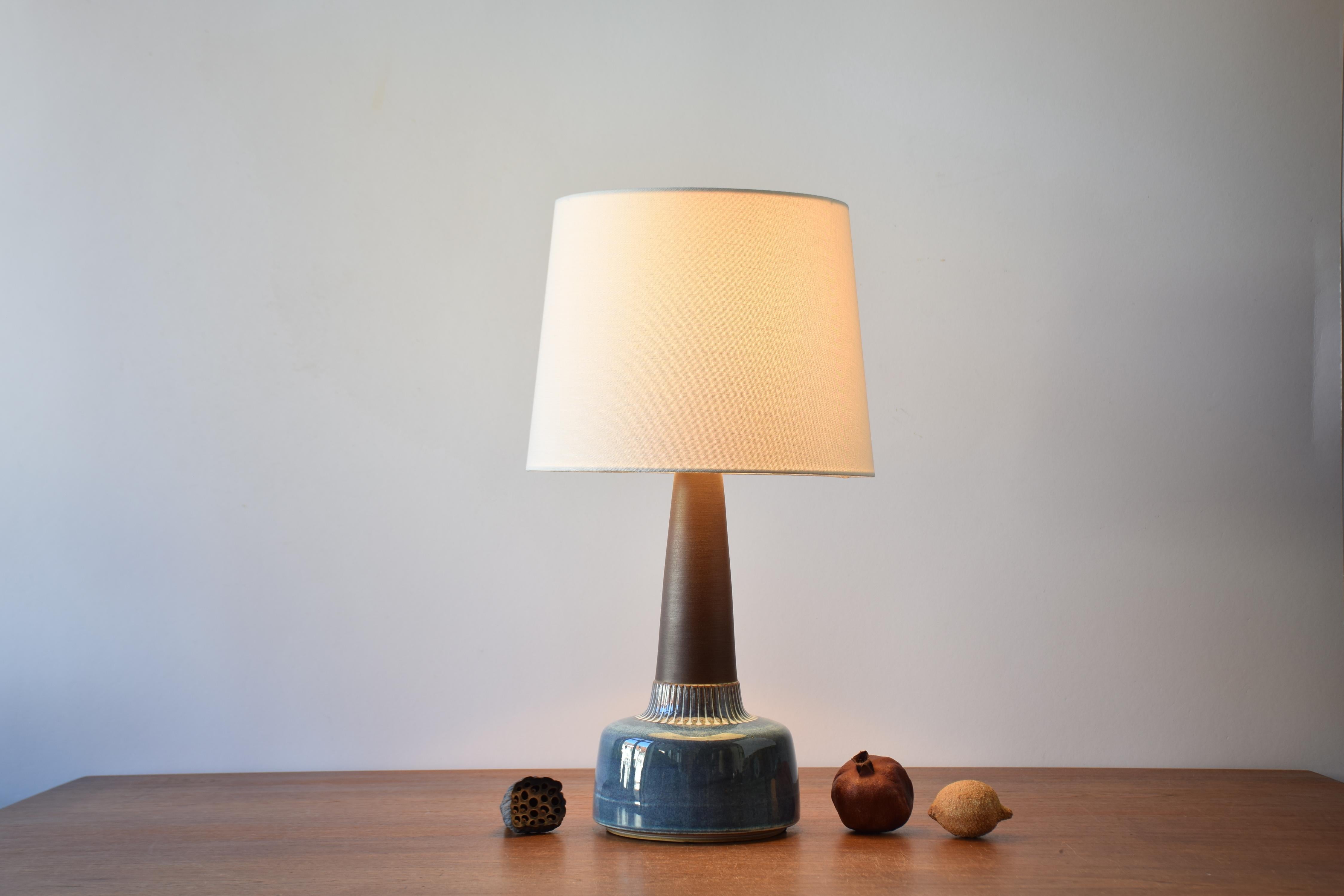Tall Mid-century Danish table lamp by Danish ceramist Einar Johansen for Søholm. Made circa 1960s.

The lamp base has a matte brown neck contrasted by a shiny glaze in mother-of-pearl colors and circular dots around the lower part.

The lamp has an
