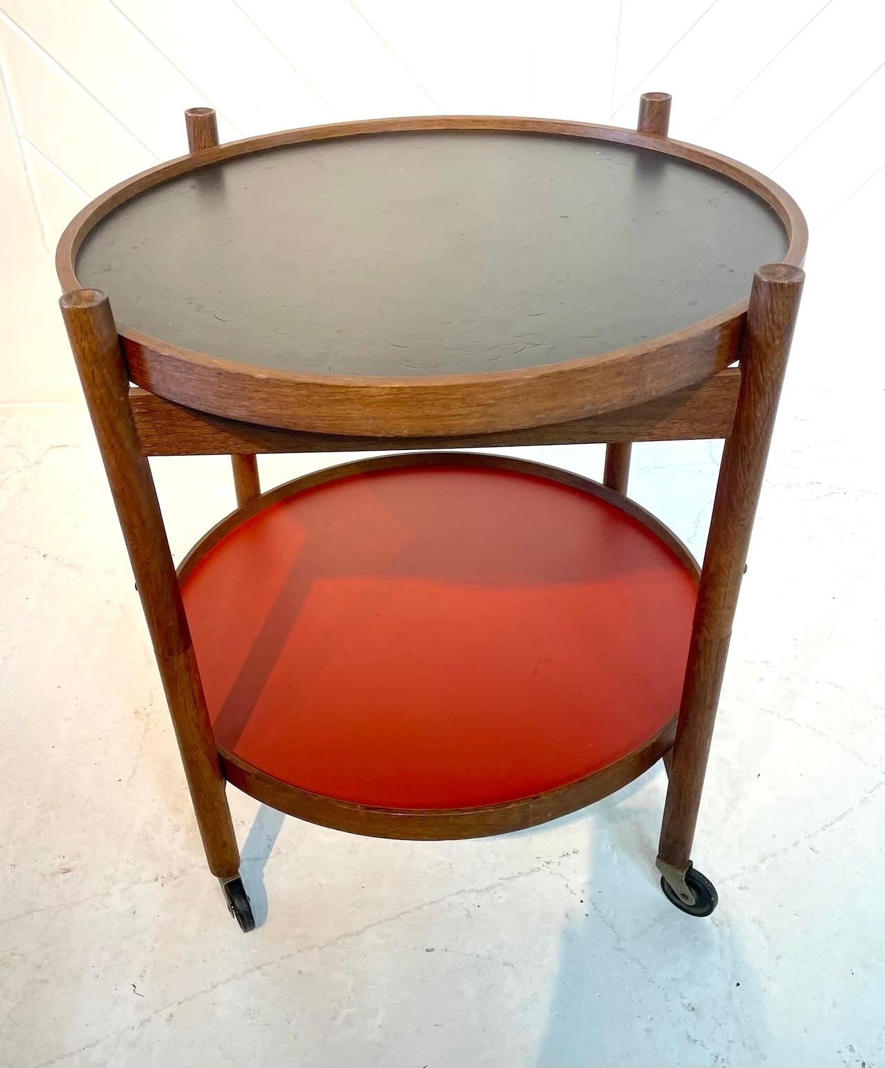 Danish oak folding trolly table on castors.
This table has reversible black and red lacquer trays, creating 4 different. colour ways
There is a makers stamp to the base.
Designed by Hans Bolling for Torben Orskov in 1963.