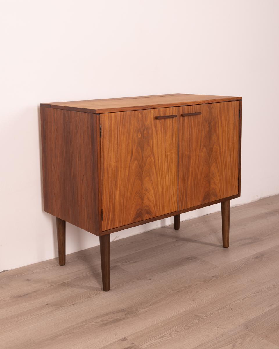 Buffet en palissandre, avec deux portes frontales et une porte supérieure à abattant, à l'intérieur un plateau et trois tiroirs. Design Kai Kristiansen pour Feldballes Møbelfabrik, années 1960.

Condit : En excellent état, peut présenter de légers