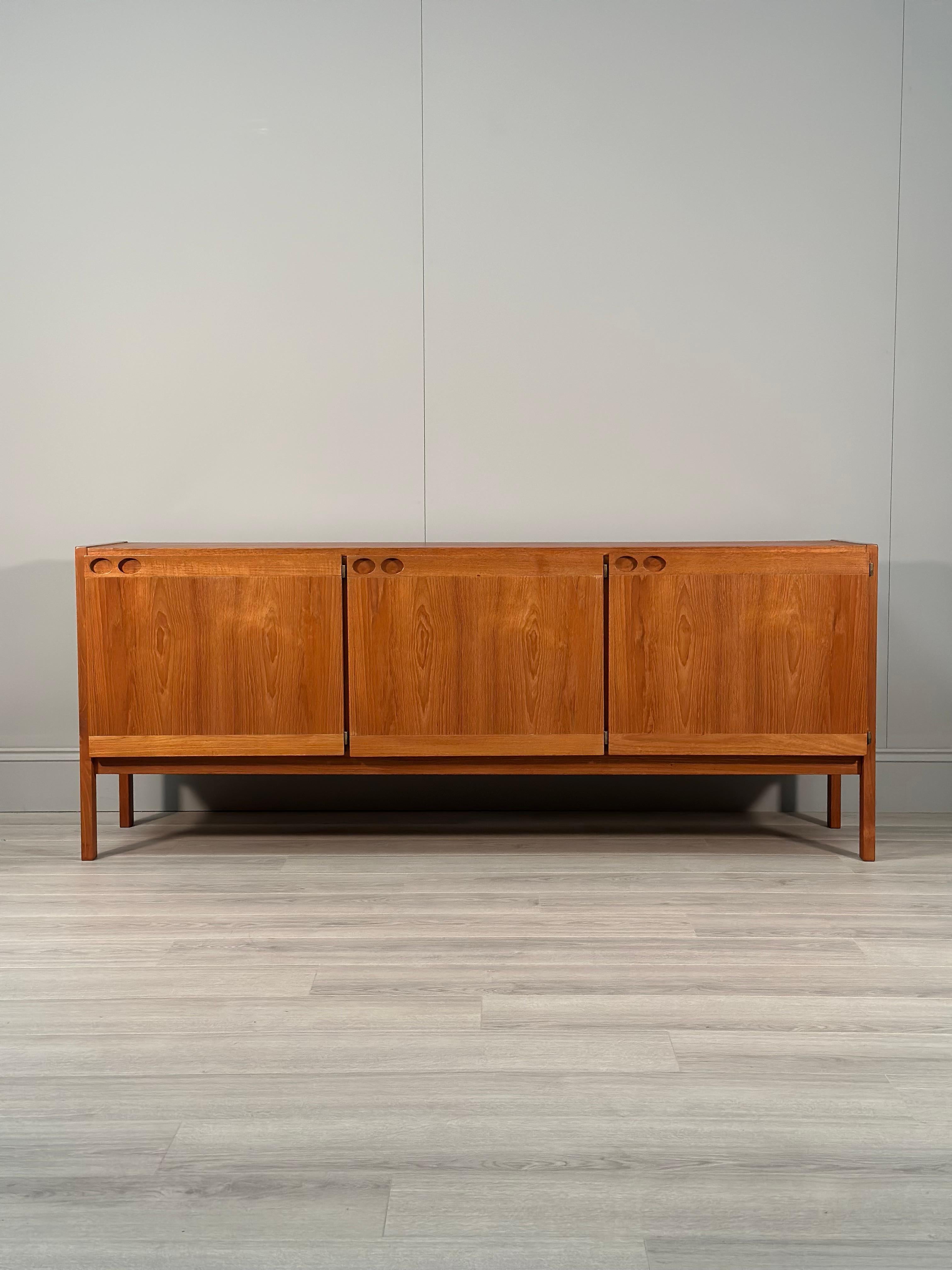Mid 20th century Danish teak sideboard designed by Ib Kofod Larsen and produced by Faarup Møbelfabrik in the 1960s. The sideboard has three doors, three inner drawers and plenty of storage space. Overall in very good conditon with some age related
