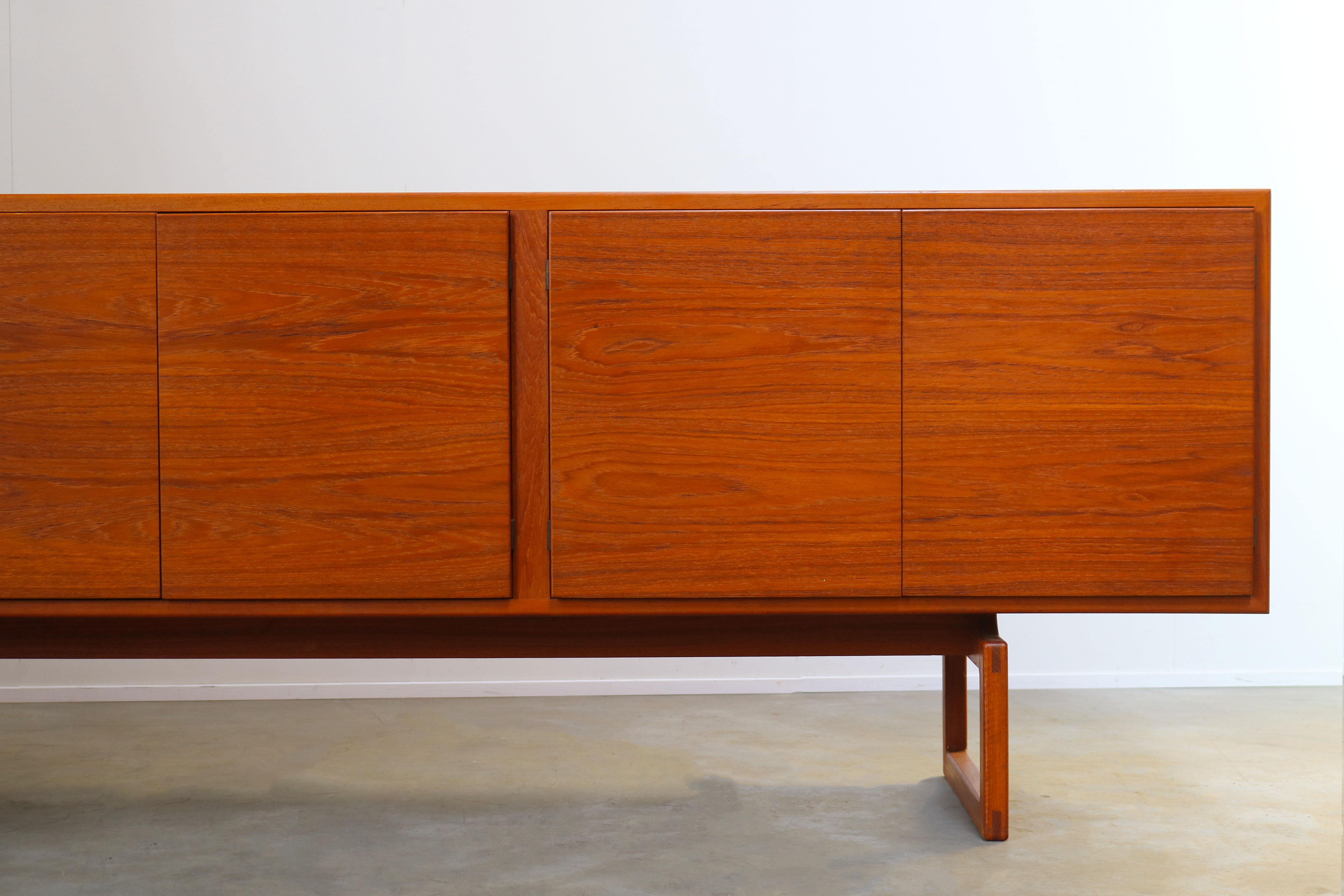 Rare Danish sideboard / credenza model: MK511 designed by Arne Hovmand Olsen for Mogens Kold. Gorgeous Minimalist modernist design in solid teak. The entire front of the cabinet is made from a single piece of teak wich results in gorgeous woodgrain