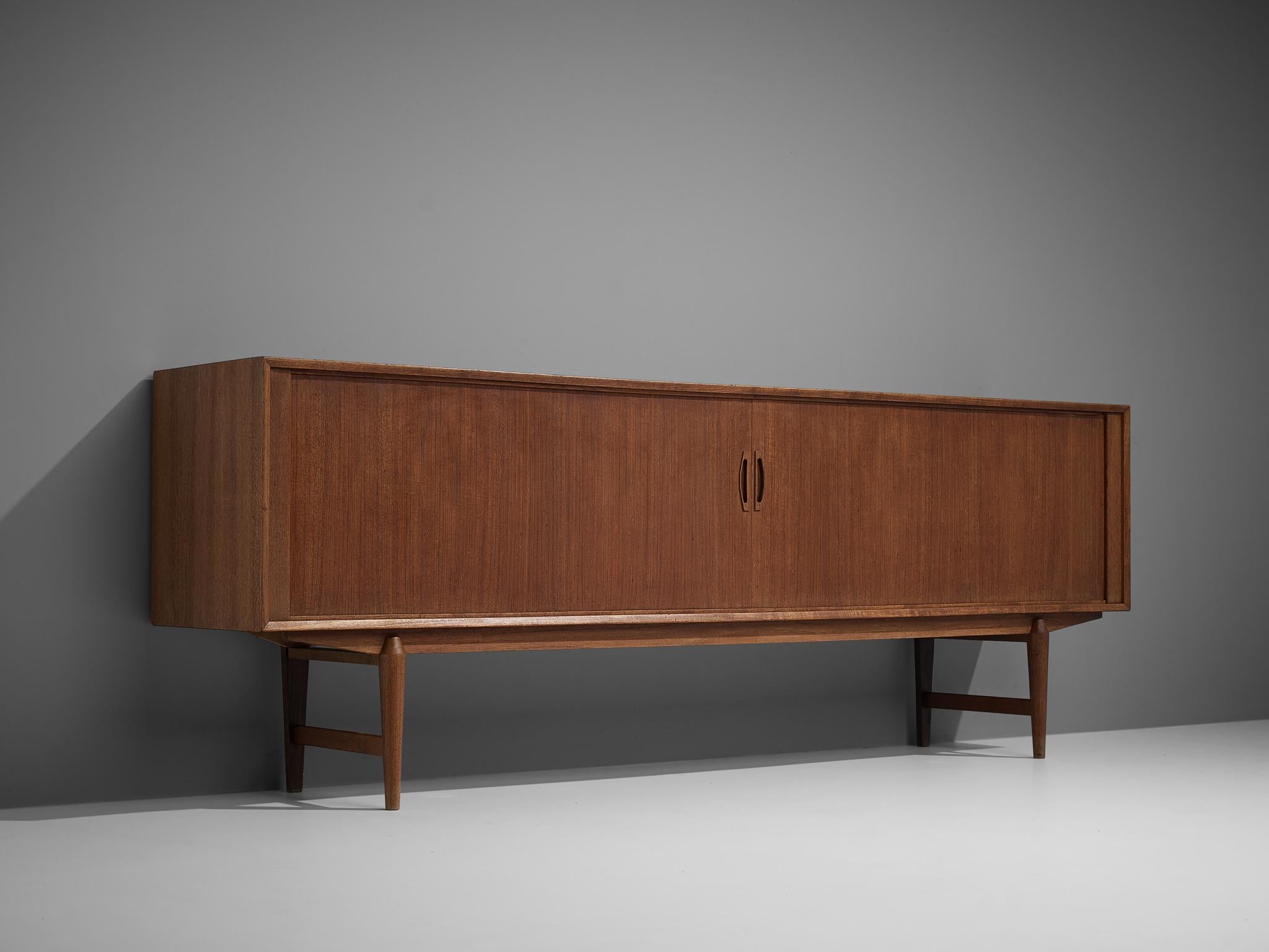 Sideboard, teak, Denmark, 1960s

Danish sideboard executed in teak. The sideboard features two sliding doors that will move inwards when opening the doors. The doors are 'framed' by a clean cut teak frame. The curved handles in the middle of the