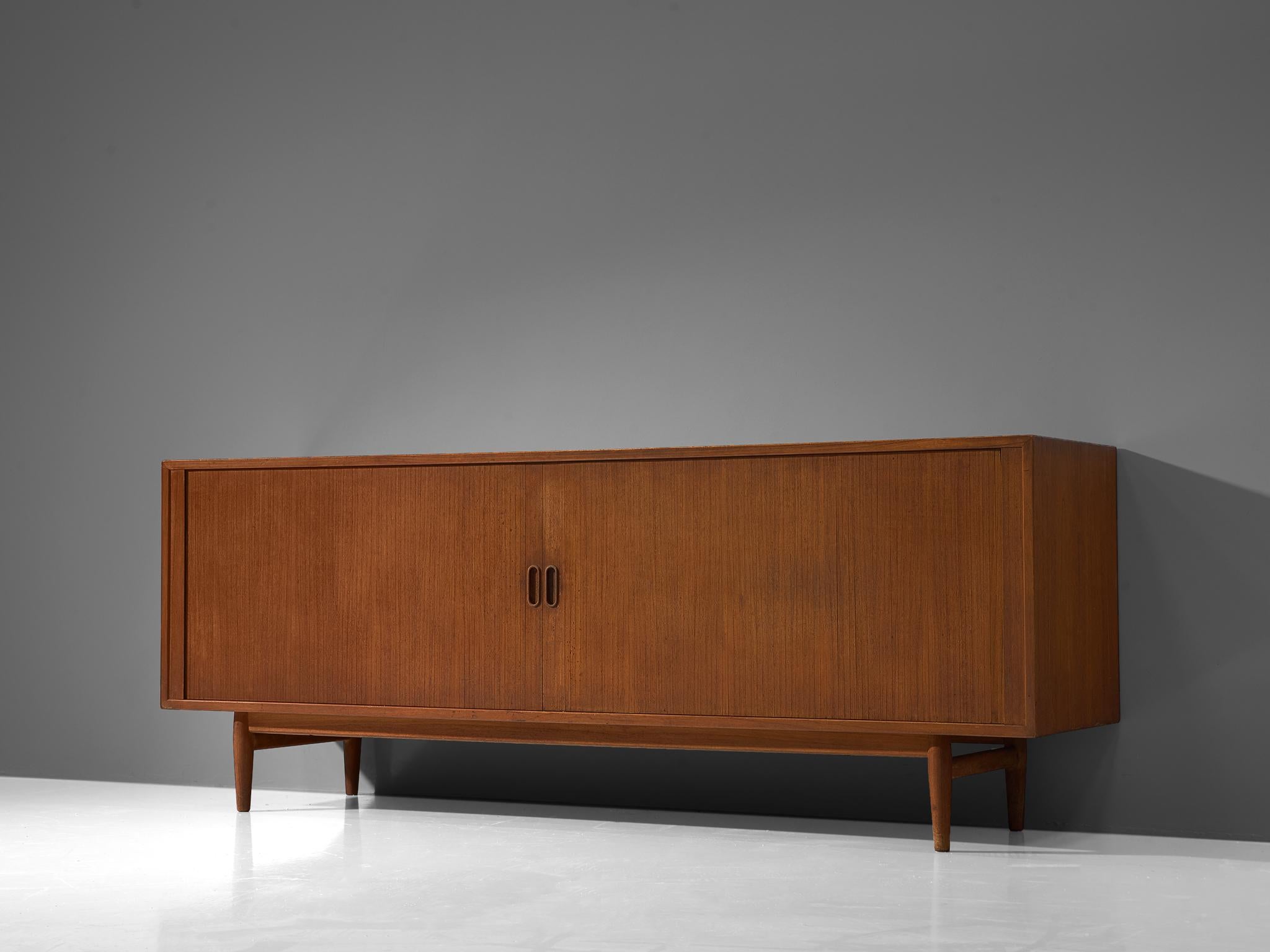 Sideboard, teak, Denmark, 1960s.

This Scandinavian Modern credenza is modest in its appearance yet highly well crafted. Sturdy and elegant with a rich teak finish and tapered legs. This beautiful piece is equipped with oval shaped handles and