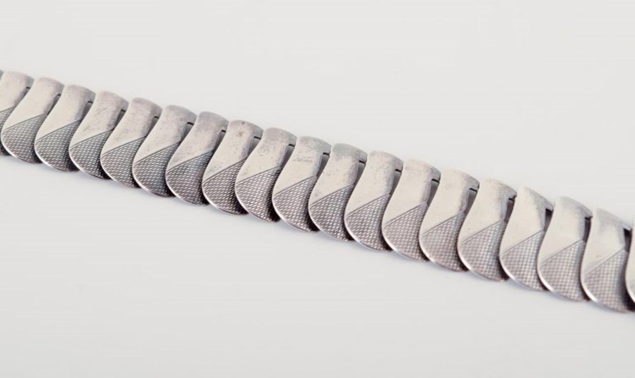 Orfèvre danois.
Bracelet moderniste en argent.
Design/One élégant.
Milieu du 20e siècle.
Poinçonné 830.
Dimensions : Longueur 18,5 cm.