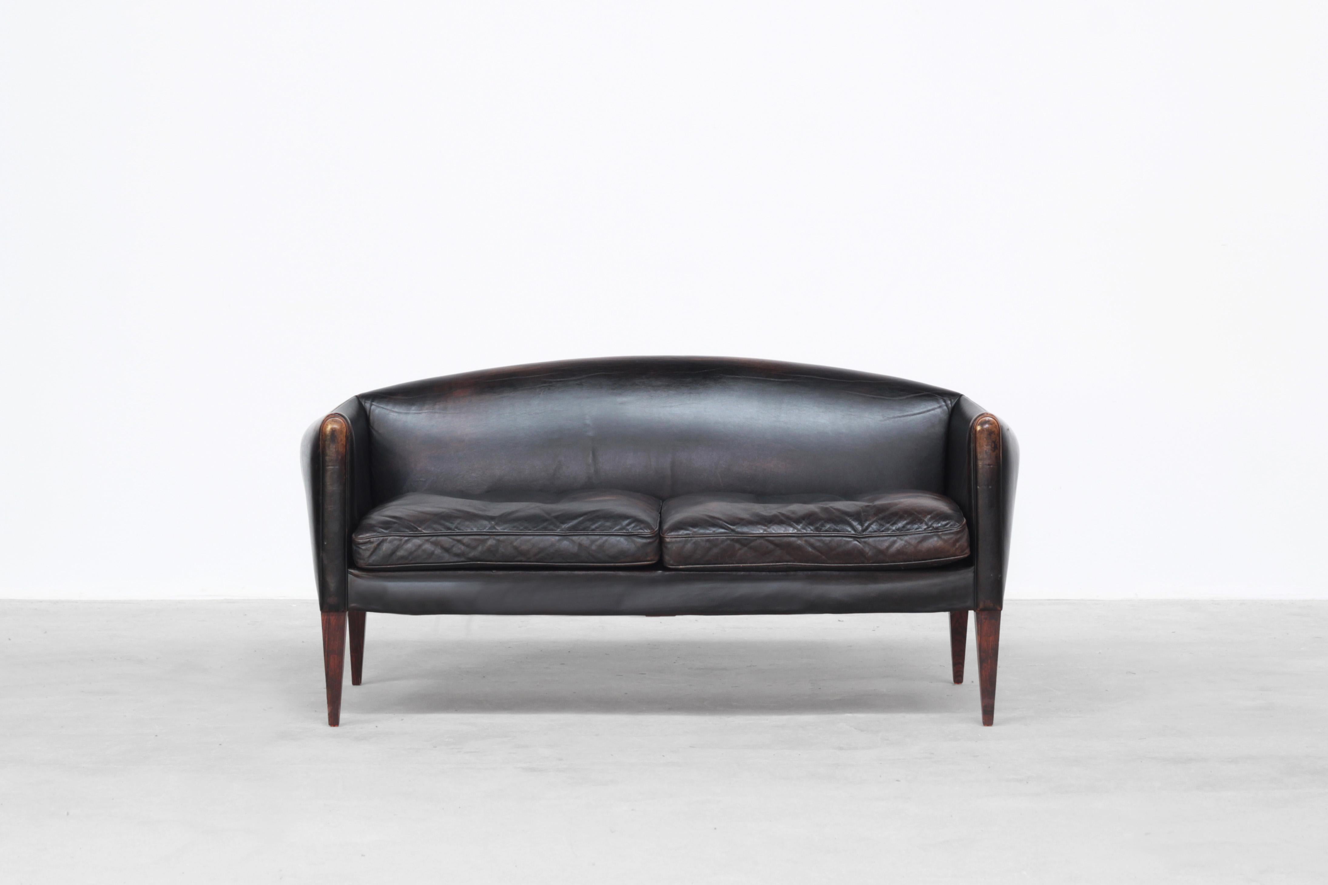 Very beautiful two-seat sofa designed by Illum Wikkelsø and produced by Holger Christiansen in the 1960s in Denmark.
The sofa comes with a beautiful patinated black leather with traces of usage. It is ready for usage.

 