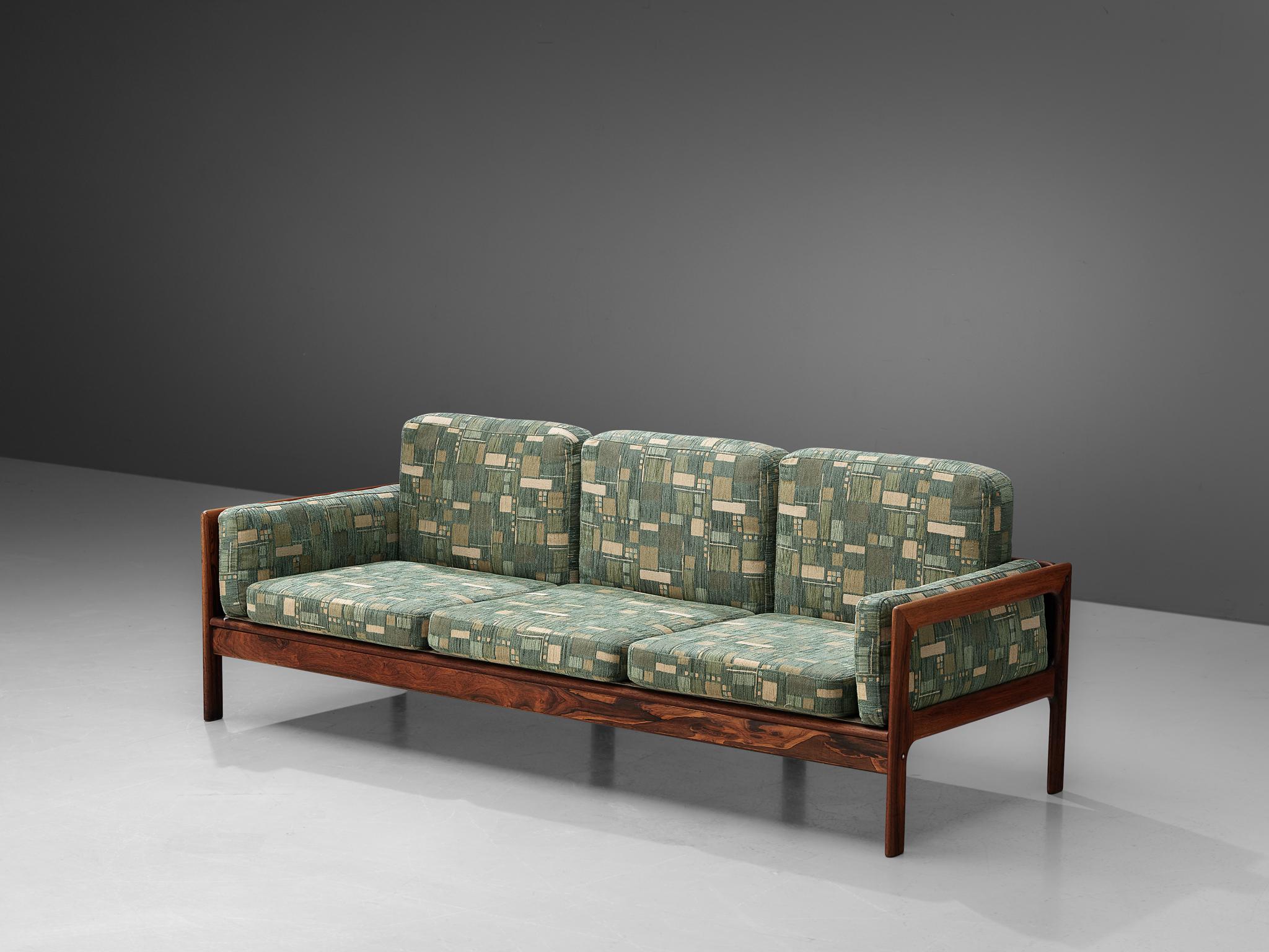 Three-seat sofa, green patterned upholstery, rosewood, Denmark, 1960s 

This highly comfortable Danish three-seat sofa has a beautiful rosewood frame in an interesting geometrical and open shape. The frame is 'boxed' around the seating, showing the