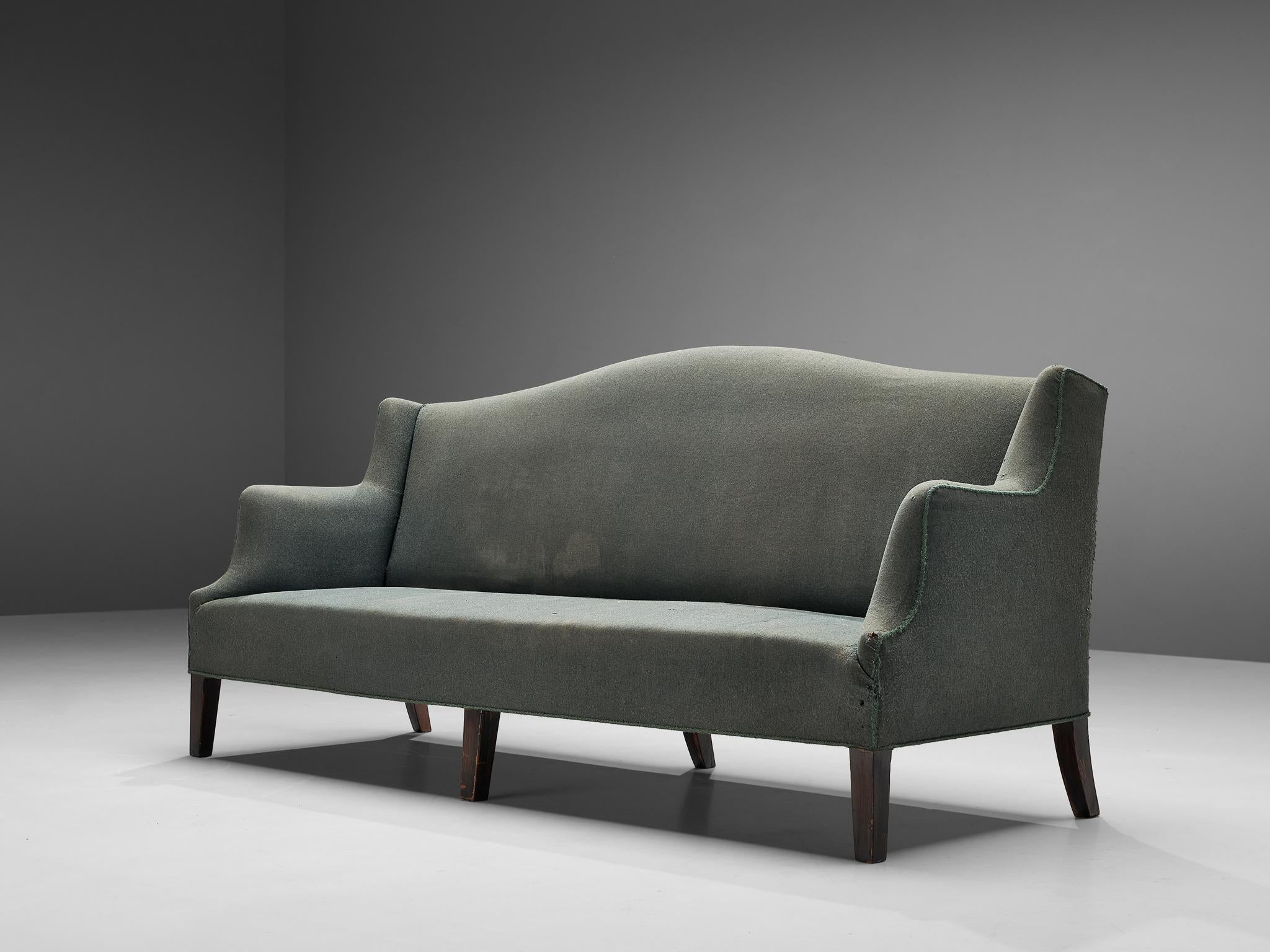 Sofa, wood, upholstery, Denmark, 1940s

This Danish sofa catches the eye due to the exquisitely shaped armrests. From the high backrest the armrests float downwards in three curves. Also the slight curve in the top end of the backrest contributes to