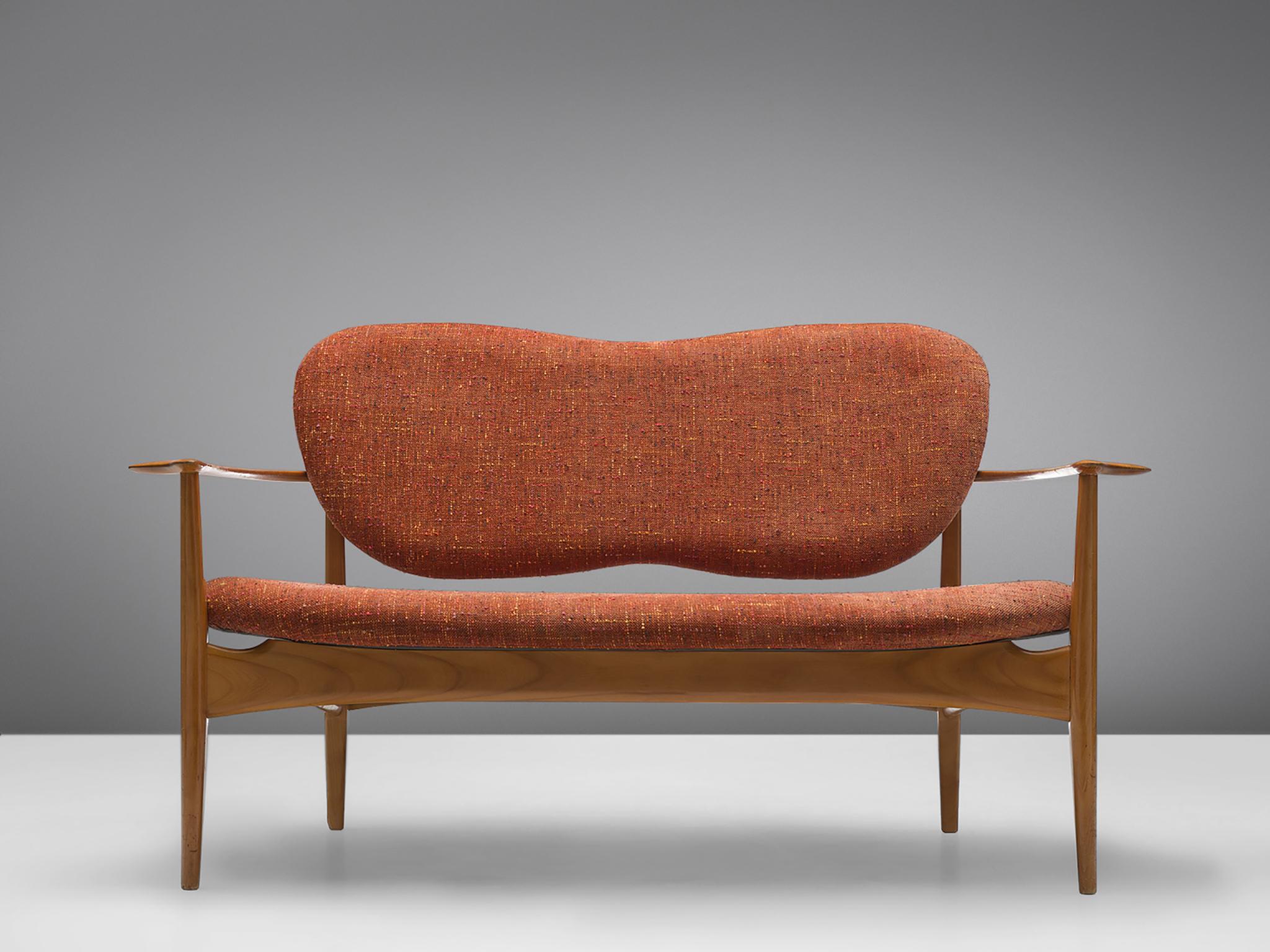 Sofa, Stoff, Kirsche, Dänemark, 1950er Jahre.

Dieses elegante, geschwungene Sofa hat eine gewellte, schmetterlingsförmige Rückenlehne und vier spitz zulaufende Holzbeine. Das Sofa ist mit hohen, geschwungenen Armlehnen ausgestattet. Der Stoff