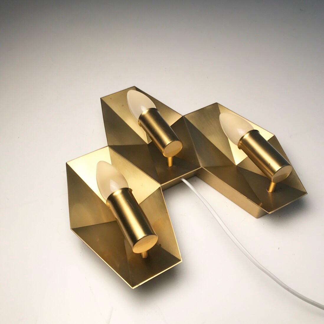 Elegant candelabra brass wall sconce made by renowned Fog & Morup, Denmark, 1950s.

Designed by Rolf Graae, danish organ builder and designer of three different lighting designs. 

The Prisme sconce (prism light) was designed back in 1950s for
