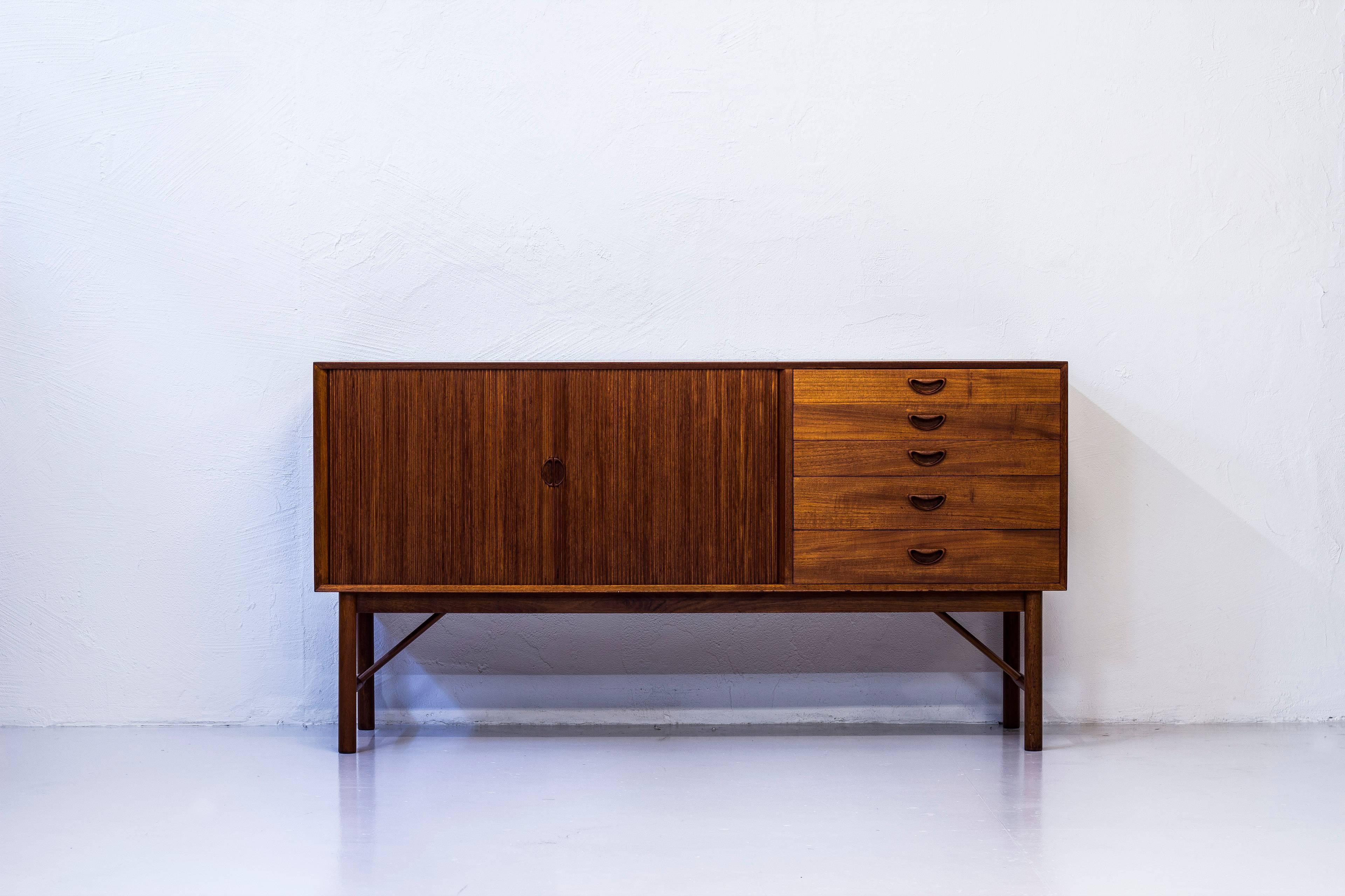 Sideboard designed by Peter Hvidt & Orla Mølgaard Nielsen. Produced in Denmark by Søborg furniture during the 1950s. Made almost entirely in solid teak wood. Exceptionally well crafted with zipper joinery in the corners, tambour doors and sculpted