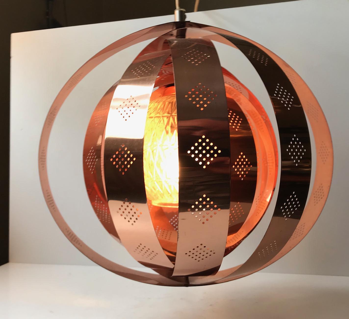 A rare Danish hanging light composed of rotating/modular copper rings and a centre shade in pressed glass. This Space Age design enables you to create a variety of different shapes. The most obvious ones being a moon or the outlines of the planet