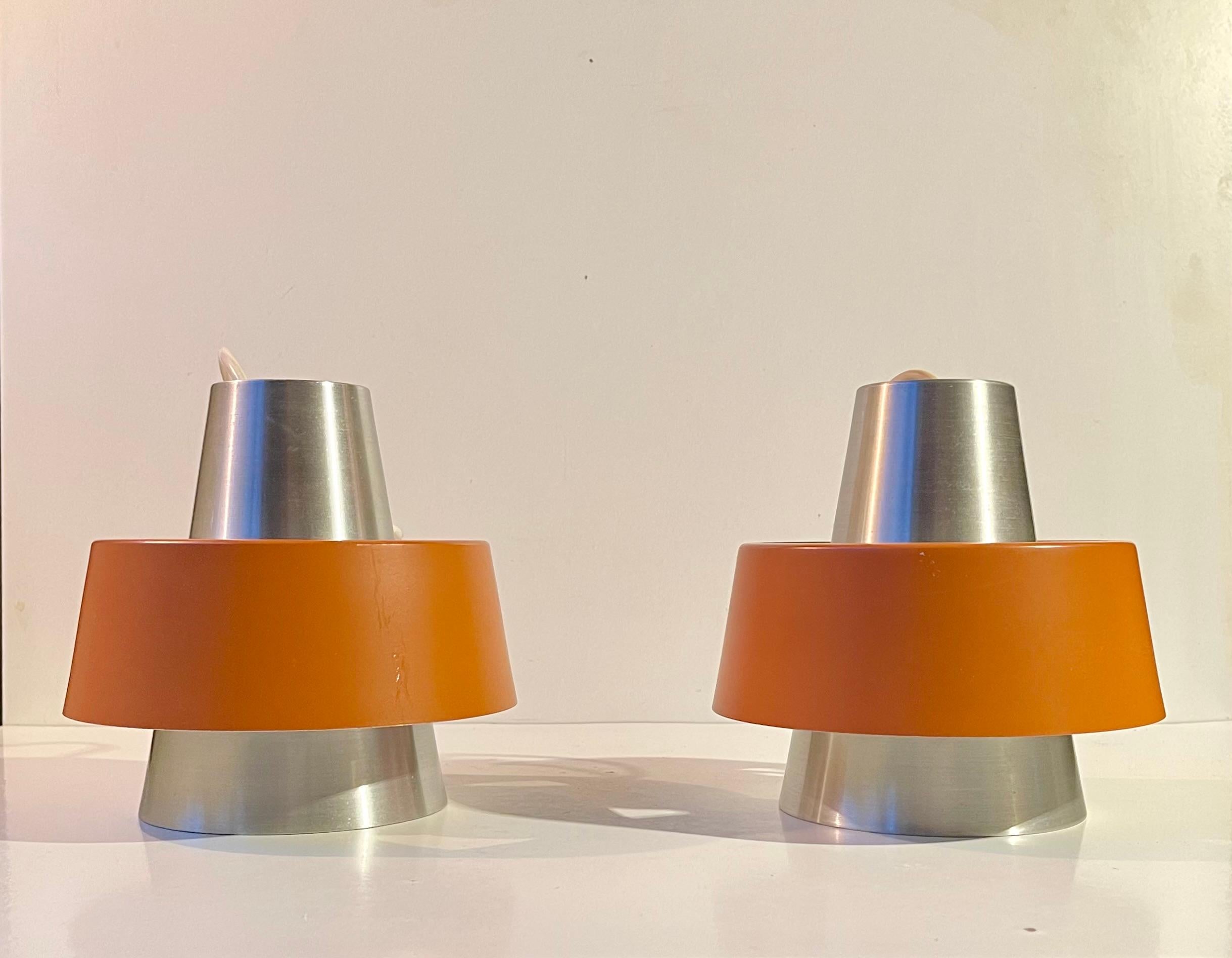 A rare set of hanging ceiling lamps in earthy orange and brushed aluminum. This model was made at Nordisk Solar Compagni in Denmark circa 1960-65. Some believe this is actually a variation of Jørn Utzon's P254 that were also made at NSC at the same