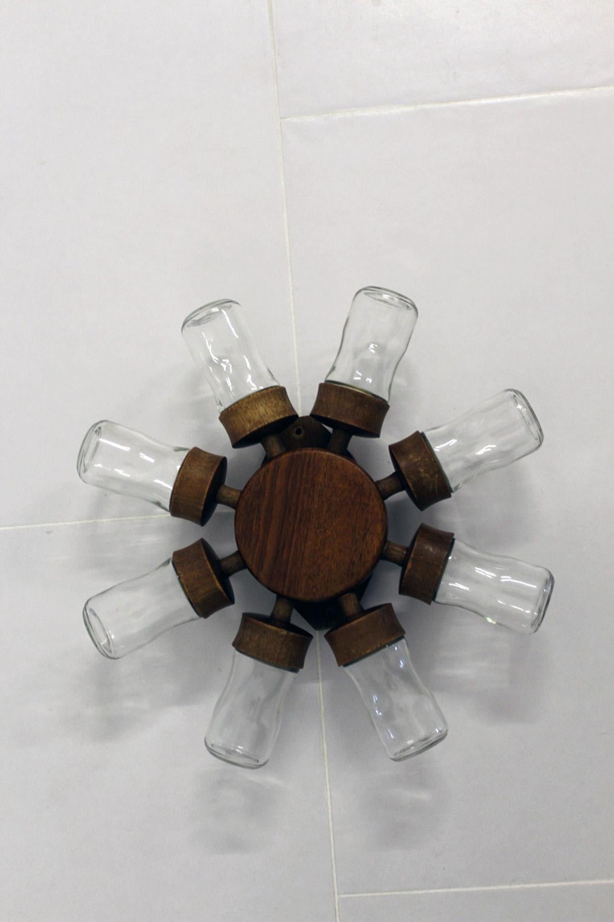 This spice wheel for wall mounting with rotating teak wood frame features 8 removable glasses as containers for spices. Original from the 1960s.