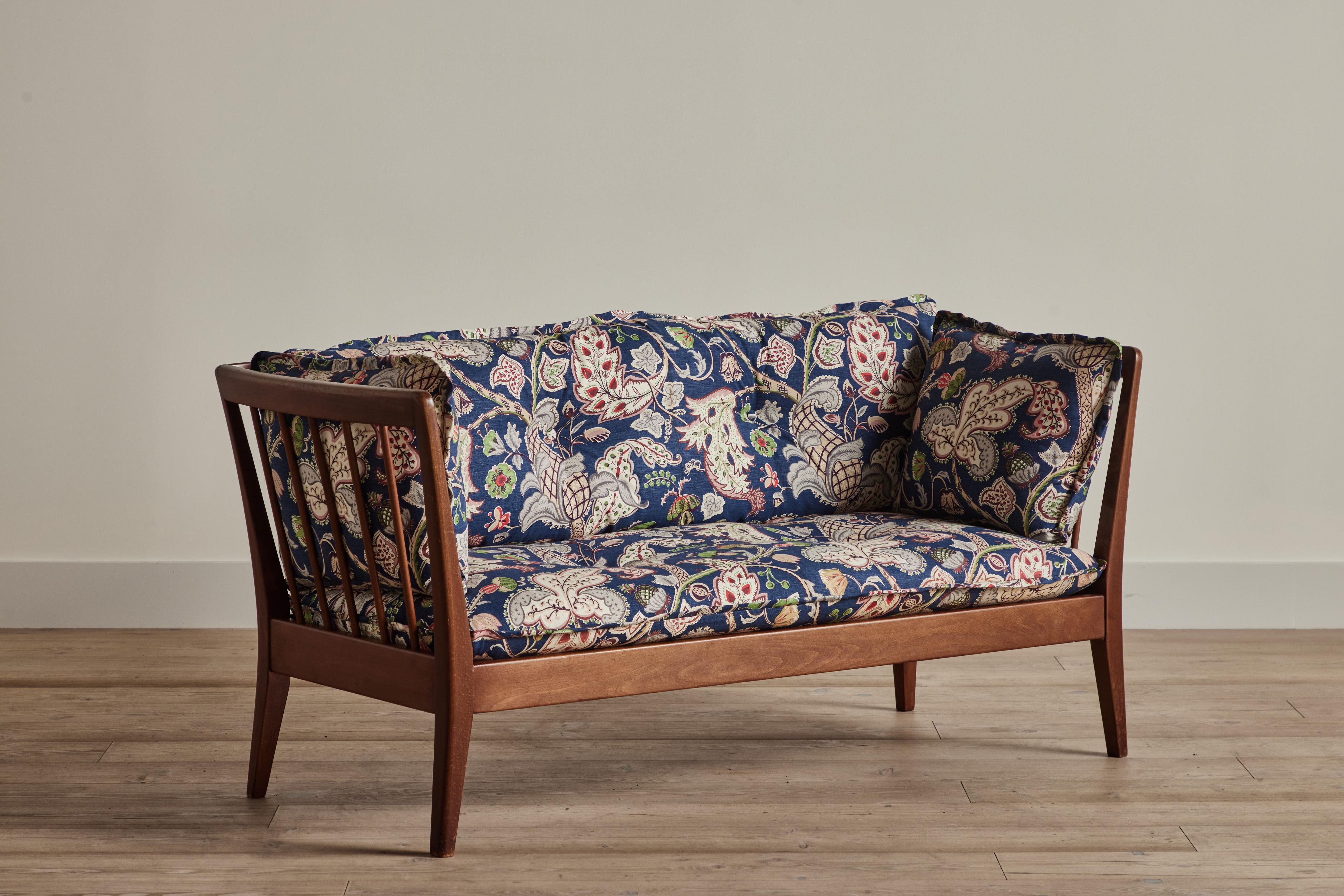 Spindle back settee from Denmark circa 1960 with new cushions upholstered in vintage deadstock fabric.
