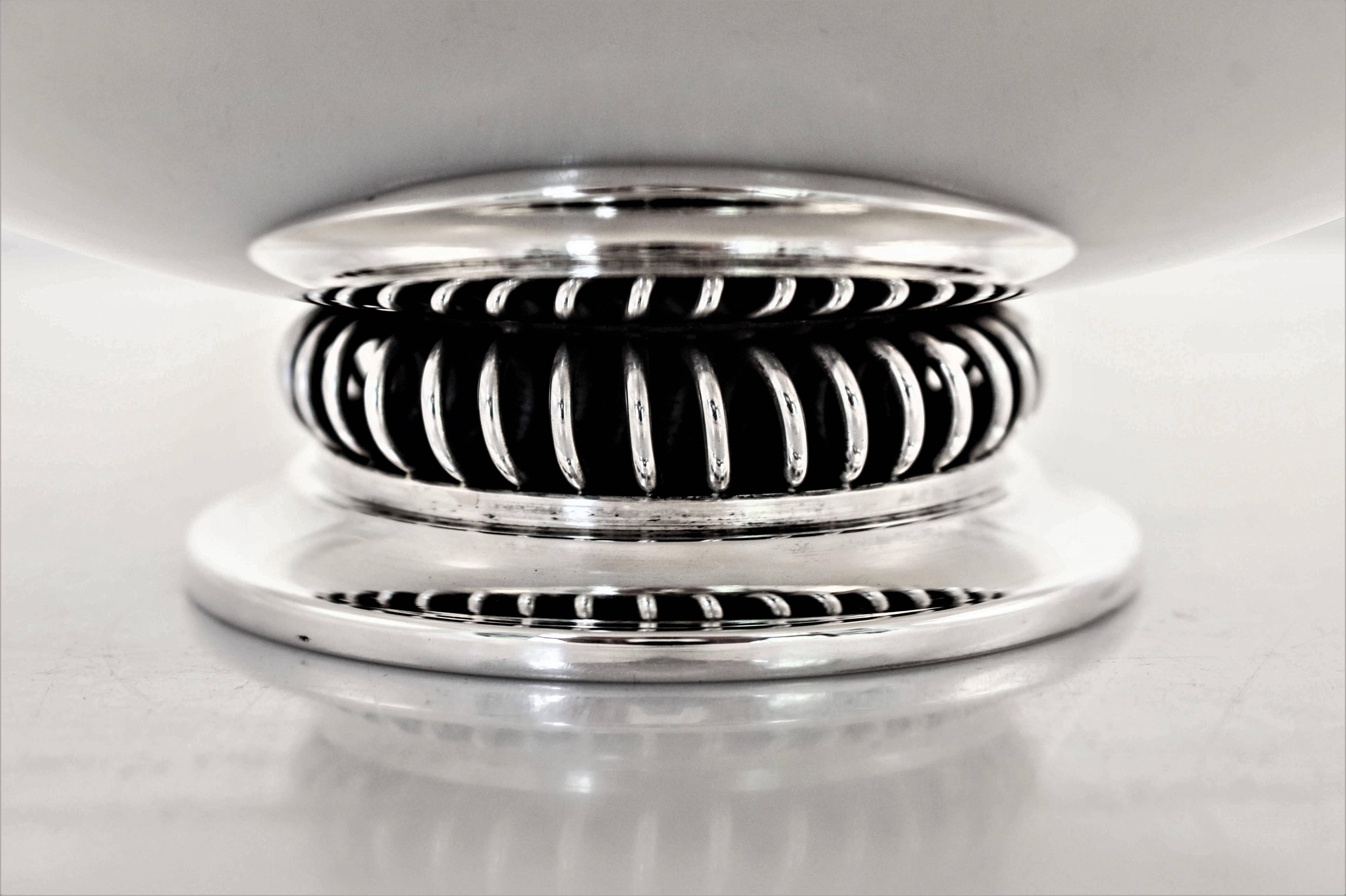 Danish silversmiths are known for their uber-modern hollowware and here’s an example. There are no decorations or designs on this piece, it has a clean top. The only detail it does have is the coil-like design around the pedestal (not weighted).