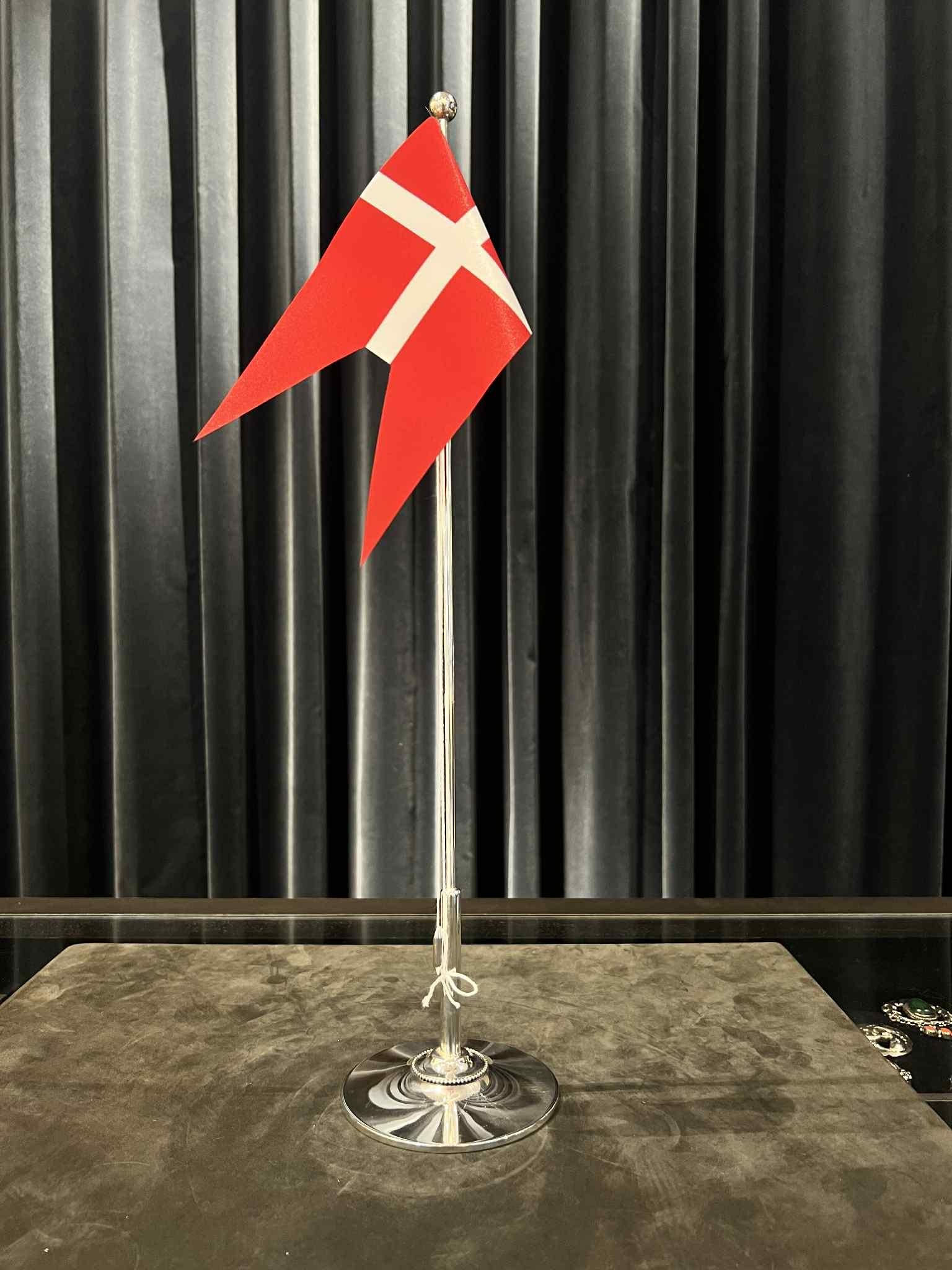 Un asta de bandera danesa de plata de ley, hecha a mano en Dinamarca de alta calidad. Este asta de bandera tiene una base redonda con un elegante anillo de cuentas que sirve de base resistente para el asta. Su parte inferior es más gruesa, lo que