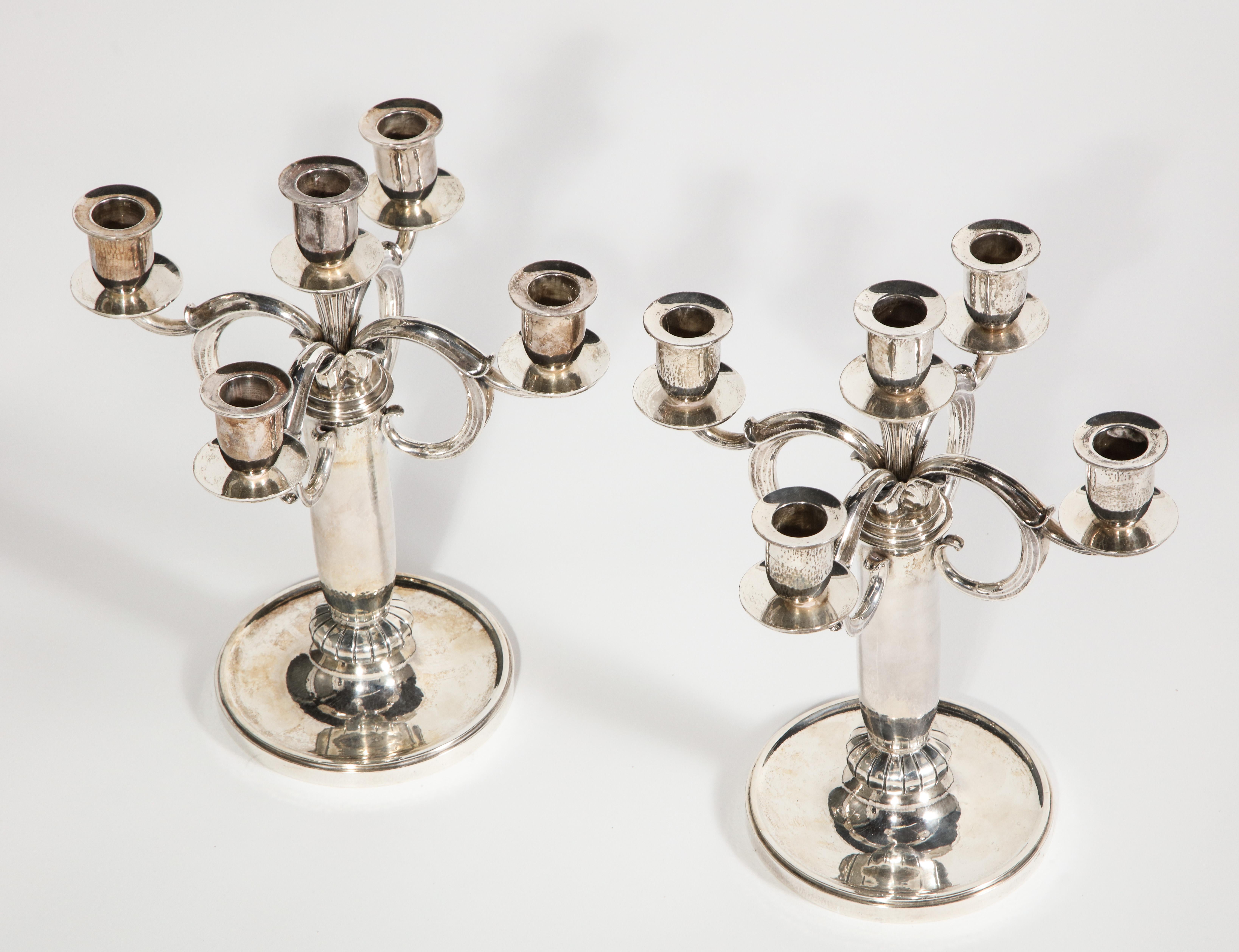 Danish sterling silver modernist five-light candelabras, pair, circa 1932, by Evald Nielsen, Copenhagen

Each with all-over hand-hammered surface, the circular concave foot issuing a shaped standard with a low fluted know with four stylized scroll